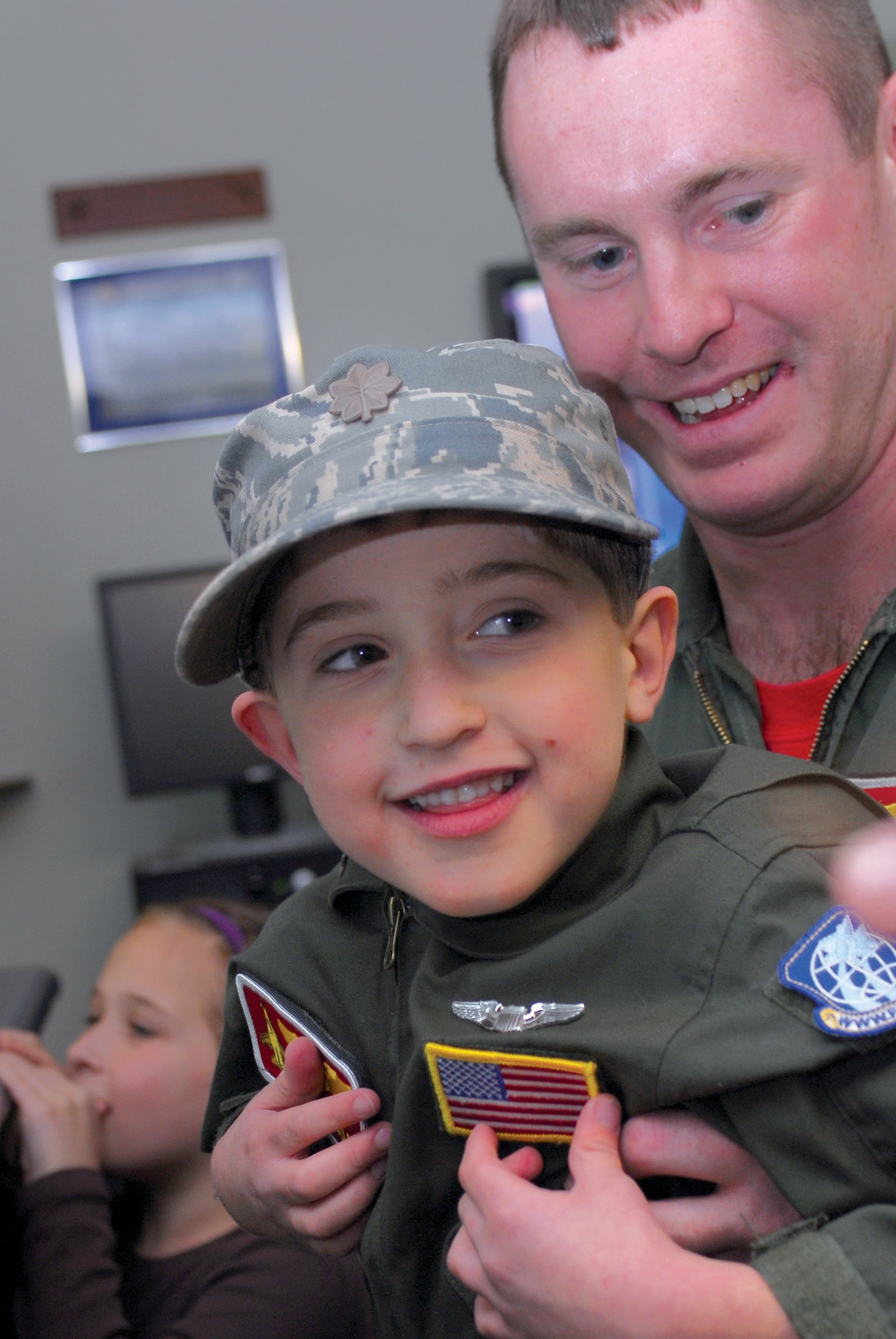 Capt. Matthew Acer, with the 56th Operations Support Squadron, lifts Pilot-for-a-day Micah Fraley, 6, to the top of the 62nd Fighter Squadron Operations desk for a flight briefing during his visit to Luke Air Force Base, Nov. 20. (U.S. Air Force photo by Senior Airman Tracie Forte)