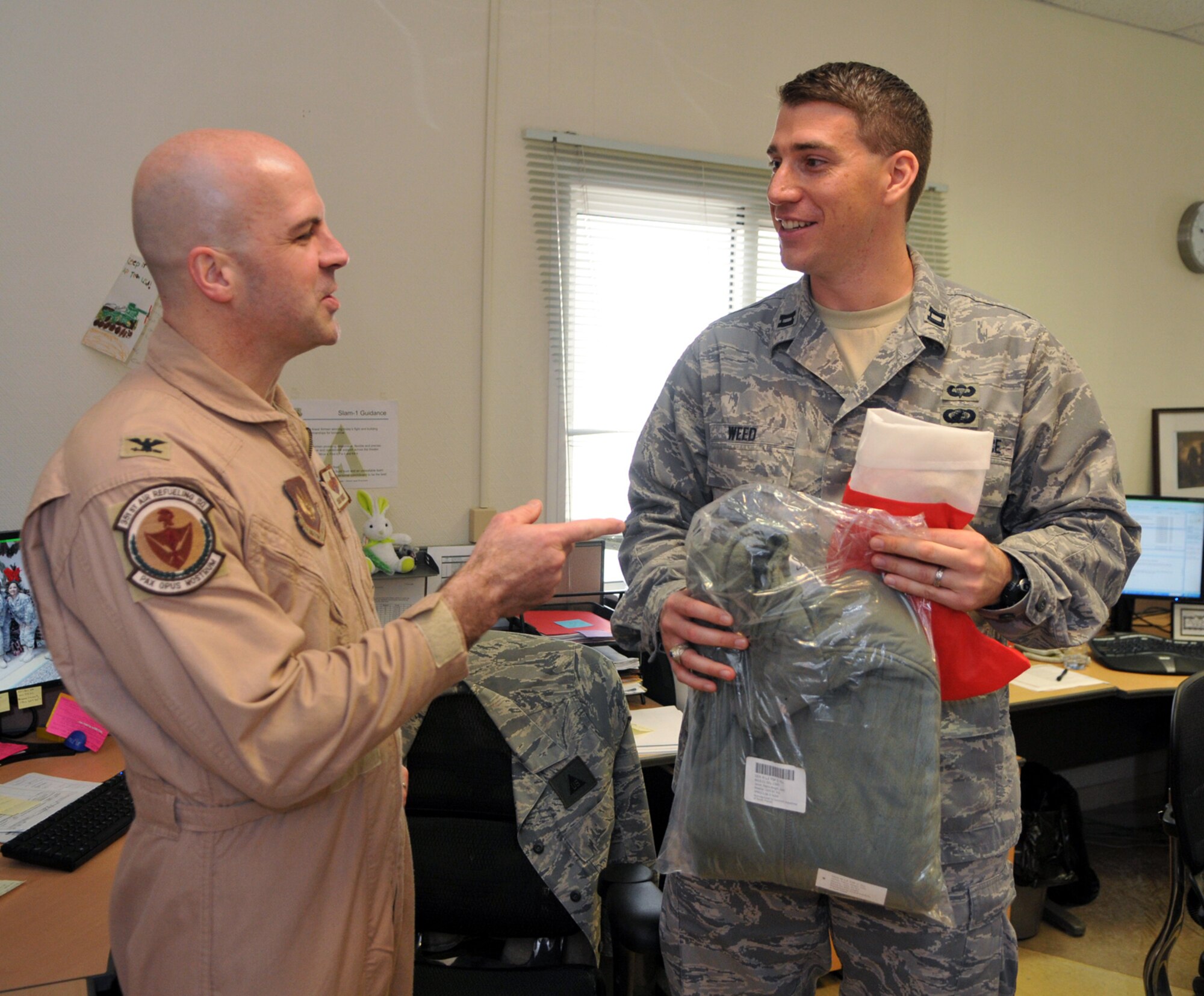 SOUTHWEST ASIA -- Col. Chad Manske, 100th Air Refueling Wing commander, delivers holiday gifts to Capt. Joshuah Weed, deployed from the 100th Air Refueling Wing, during a visit Dec. 18.  Colonel Manske travelled with Chaplain (Lt. Col.) Frederick Viccellio to the Middle East to hand deliver treats and encouragement during the holidays.  (U.S. Air Force photo by Staff Sgt. Austin M. May)