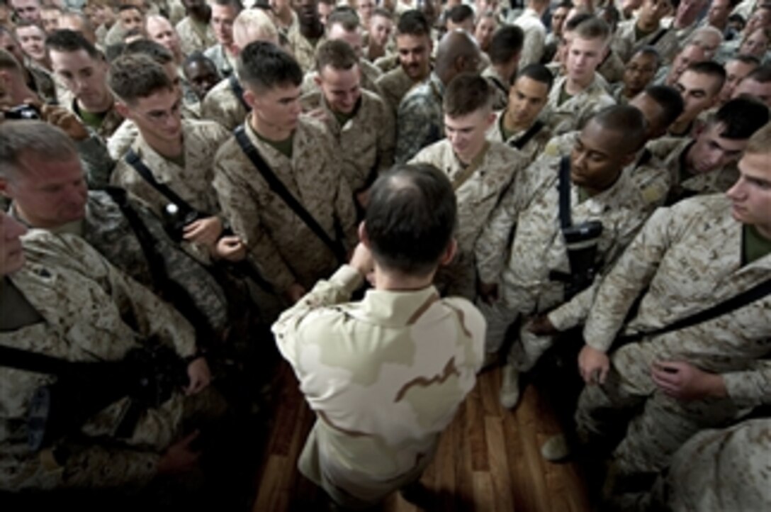 Chairman of the Joint Chiefs of Staff Adm. Mike Mullen, U.S. Navy, hands out coins to service members stationed at Al-Asad Air Base, Iraq on Dec. 19, 2009.  Mullen and his wife Deborah are hosting the USO holiday troop visit with tennis star Anna Kournikova, comedian Dave Attell, tennis coach Nicholas Bollettiere and musician Billy Ray Cyrus visiting troops in Afghanistan, Iraq and Germany.  