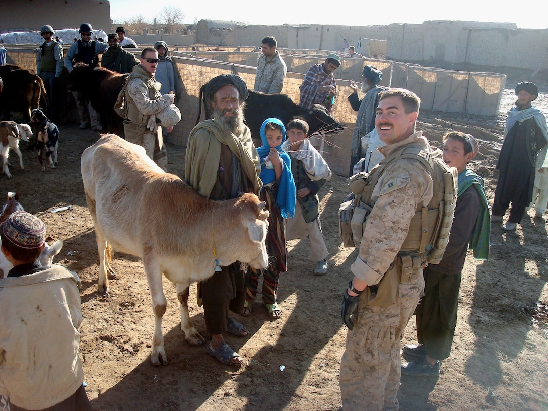 Capt. Christopher Banweg, a civil affairs group team leader, talks to local farmers about livestock concerns during a veterinarian assistance mission which his team conducted in the Khan Neshin Bazaar here Dec. 23, 2009.  Banweg is a member of 4th Civil Affairs Group, a Marine Forces Reserve unit headquartered in Washington, D.C.