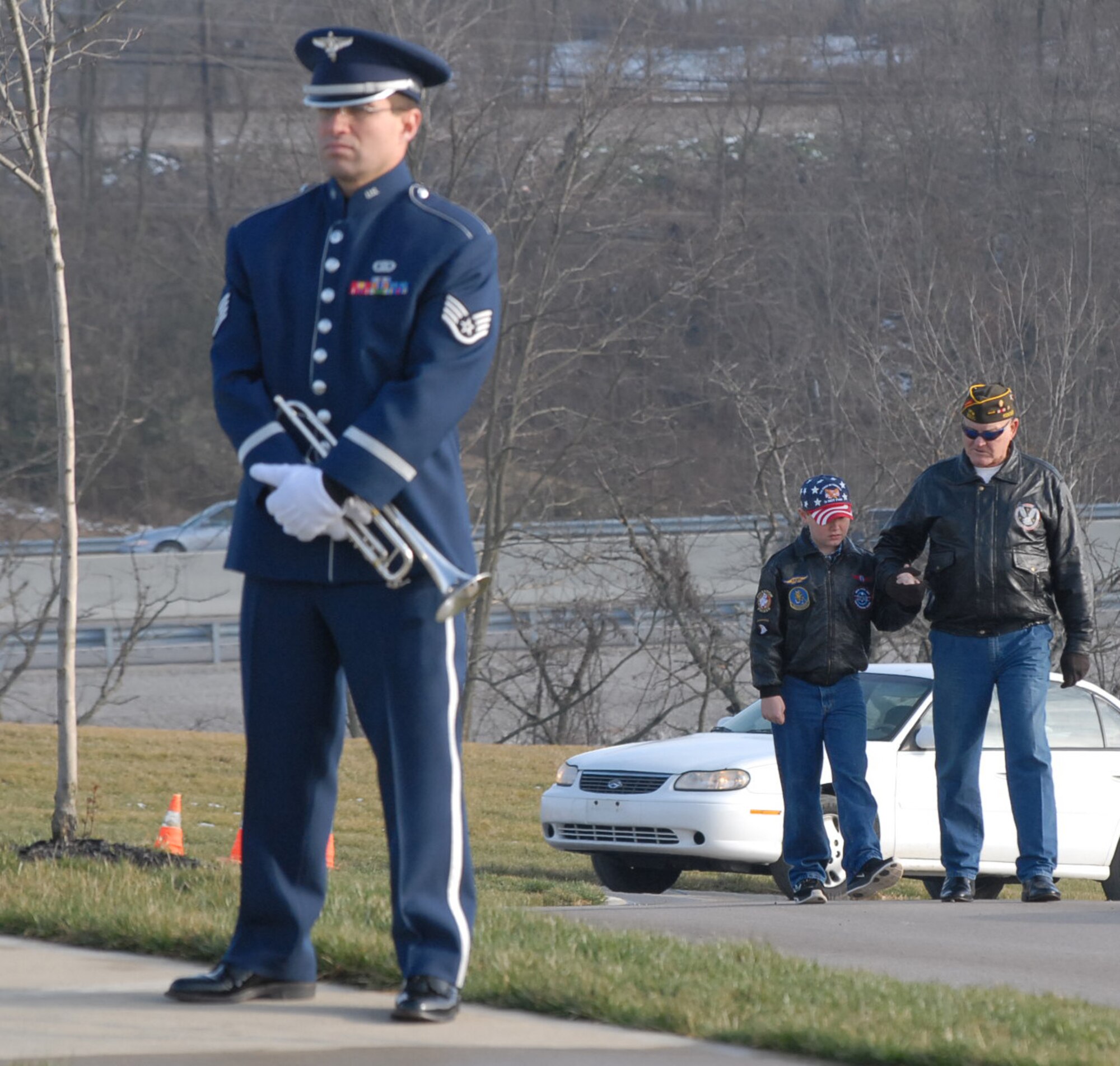 While an Air Force bugler waits to play for the military funeral, visitors make their way up the hill at Kentucky Veterans Cemetery to celebrate the life of Tech. Sgt. Anthony Campbell, who died recently during Operation Enduring Freedom.  He was buried Tuesday, December 22, in Williamstown, Ky.  (U.S. Air Force photo/Maj. Stan Paregien)