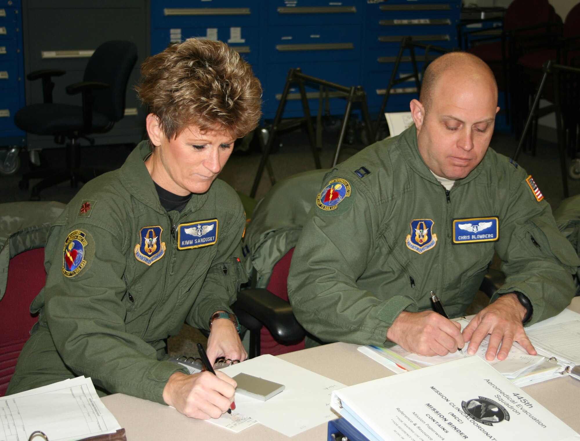 WRIGHT-PATTERSON AIR FORCE BASE, Ohio – Maj. Kimberlee Sandusky and Capt. Christopher Blomberg, both from the 445th Aeromedical Evacuation Squadron, write down patient information during a crew mission briefing before an AES training flight Dec. 16. Members of the 445th AES are ready to fill the need when events like natural disasters, war or routine medical transportation by air is required. (U.S. Air Force photo/Senior Airman Matthew Cook)