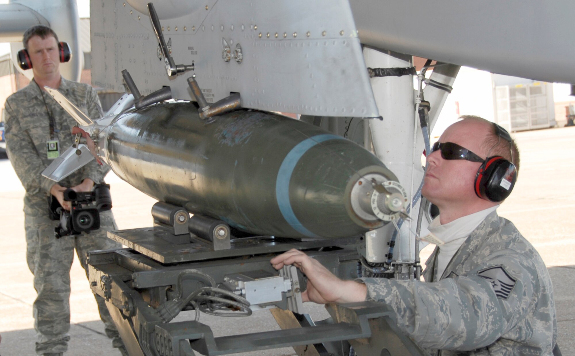 Tech Sgt. Josh Jones, left, a member of the 188th Fighter Wing, records video footage of the 188th's Master Sgt. Albert Wright as he loads an MK-82, 500-pound bomb during initial certification training on an A-10C Thunderbolt II "Warthog" Nov. 7, 2009. Jones, who is the head football coach at Magazine High, was named Class 2A Coach of the Year by Hooten's Arkansas Football, the state's largest sports publication that focuses on football. Jones' Magazine Rattlers set multiple school records, including wins, playoff victories, total offense and points scored. Jones has been a member of the 188th for 14 years. (U.S. Air Force photo by Tech Sgt. Stephen Hornsey/188th Fighter Wing Public Affairs)