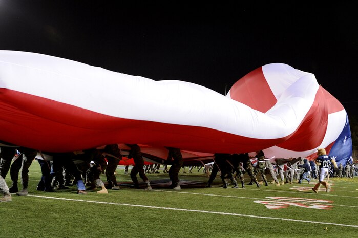 LAS VEGAS - Airman from Nellis and Creech Air Force Bases fight against high winds as they fold a giant American flag after pre-game ceremonies at the MAACO Las Vegas Bowl featuring the Brigham Young University Cougars and the Oregon State Beavers at Sam Boyd Stadium Dec. 22. 
(U.S. Air Force photo by Tech. Sgt. Michael R. Holzworth)