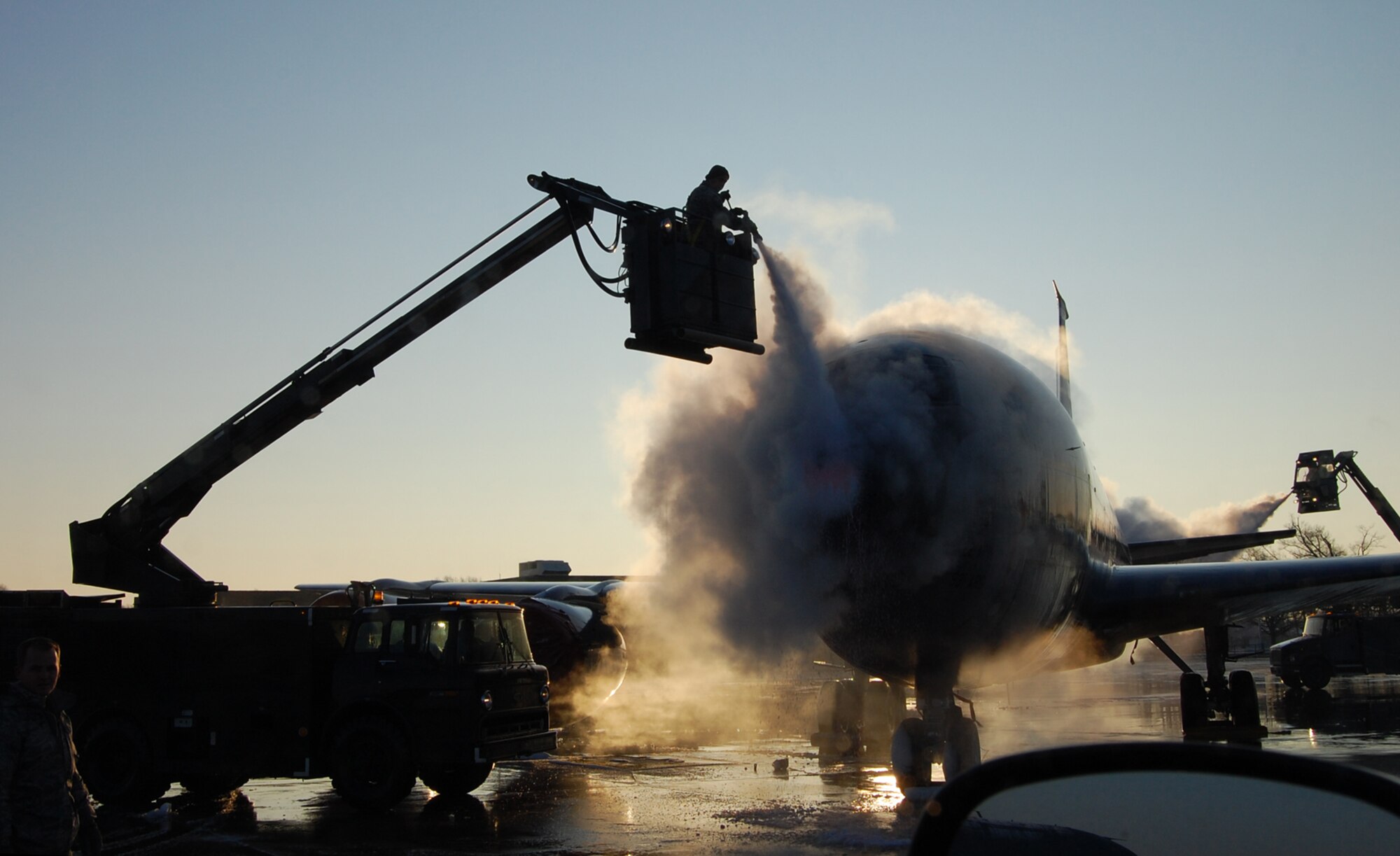 Senior Master Sgt. Eric Peel and Staff Sgt. Marshall Oswalt coat a KC-135 Stratotanker with deicing spray during a recent mission that supported the 2009 Tour for the Troops featuring singer Kid Rock and comedian Carlos Mencia. Both sergeants are Reservists assigned to the 931st Aircraft Maintenance Squadron. (Courtesy photo/Senior Airman Davin Perry)