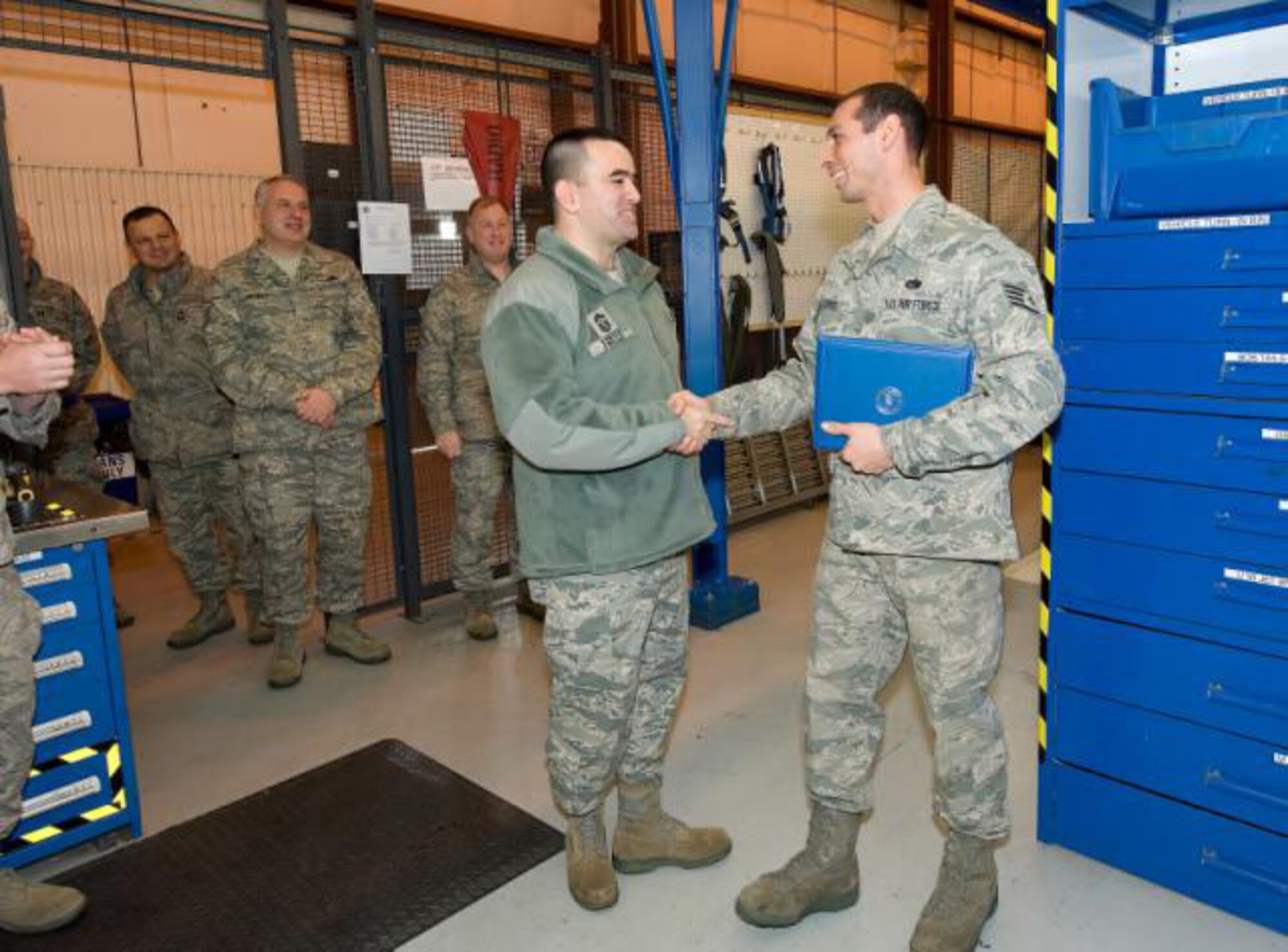 Chief Master Sgt. John Evalle, 436th Airlift Wing Command Chief congratulates Staff Sgt. Jared Flores, 436th Aerial Maintenance Squadron hydraulic craftsman on his STEP promotion to Tech. Sgt. (US Air Force Photo / Jason Minto)