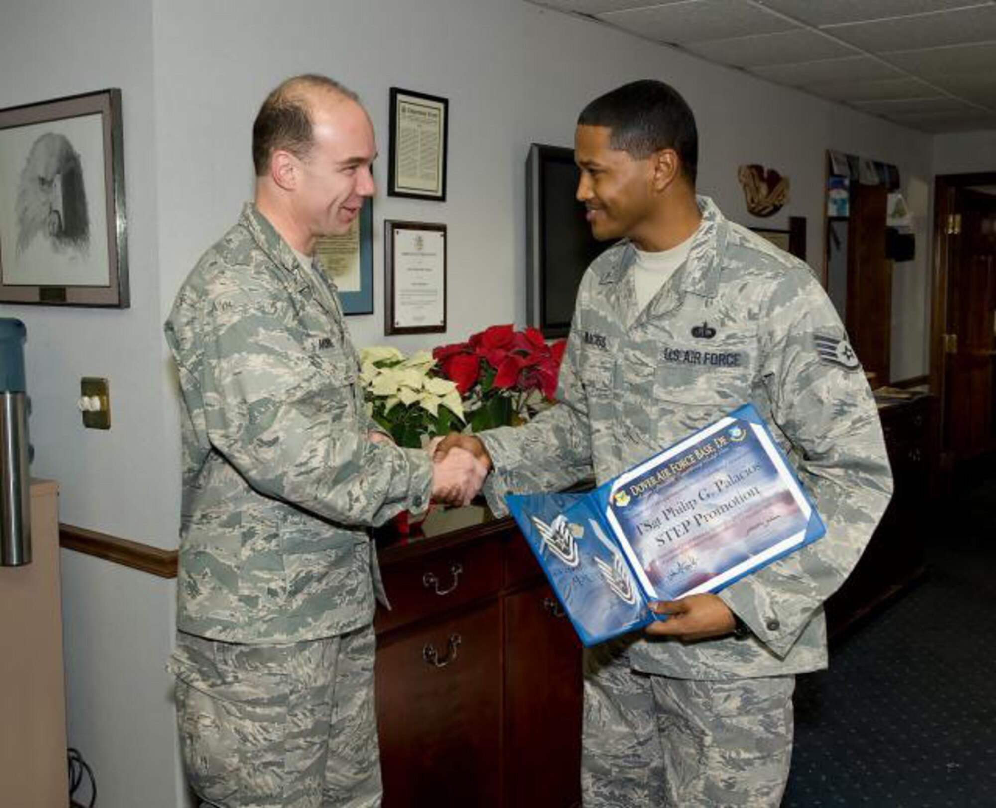 Col. Manson Morris, 436th Airlift Wing Commander, presents Staff Sgt. Philip Palacios 436th Airlift Wing non-commissioned officer in charge of protocol with a STEP promotion to Tech. Sgt. 