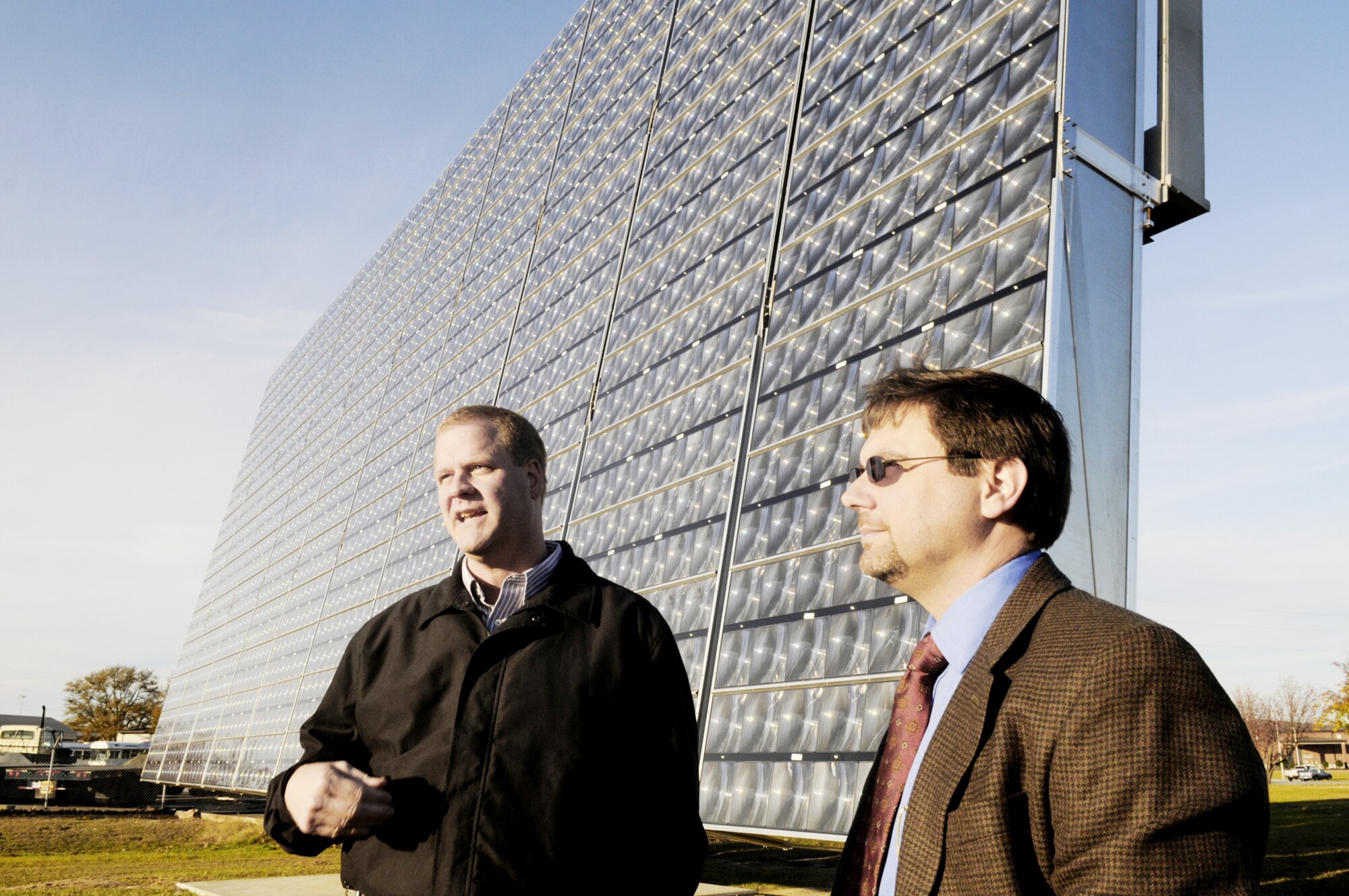 Scott Slyfield and Robert David talk about the Air Force's Advanced Power Technology Office 25kW Tracking Solar Array recently at Robins Air Force Base, Ga. Mr. David is an engineering supervisor and head of the APTO office. Mr. Slyfield is an APTO program manager. (U. S. Air Force photo/Sue Sapp)
