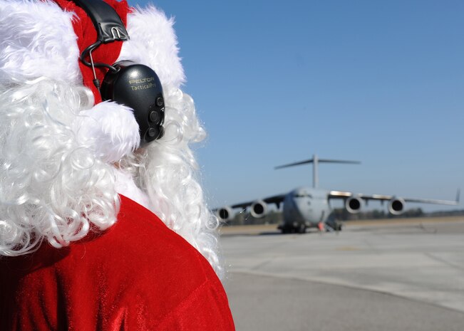 Maj. Aaron Sasson waits on the flightline here Dec. 22 to marshal in a Charleston AFB C-17 as Santa Claus. Major Sasson was voted to dress up by the 437th Aircraft Maintenance Squadron for a squadron booster club  fundraiser. Major Sasson is the 437 AMXS operations officer. (U.S. Air Force photo/Senior Airman Katie Gieratz)(RELEASED)