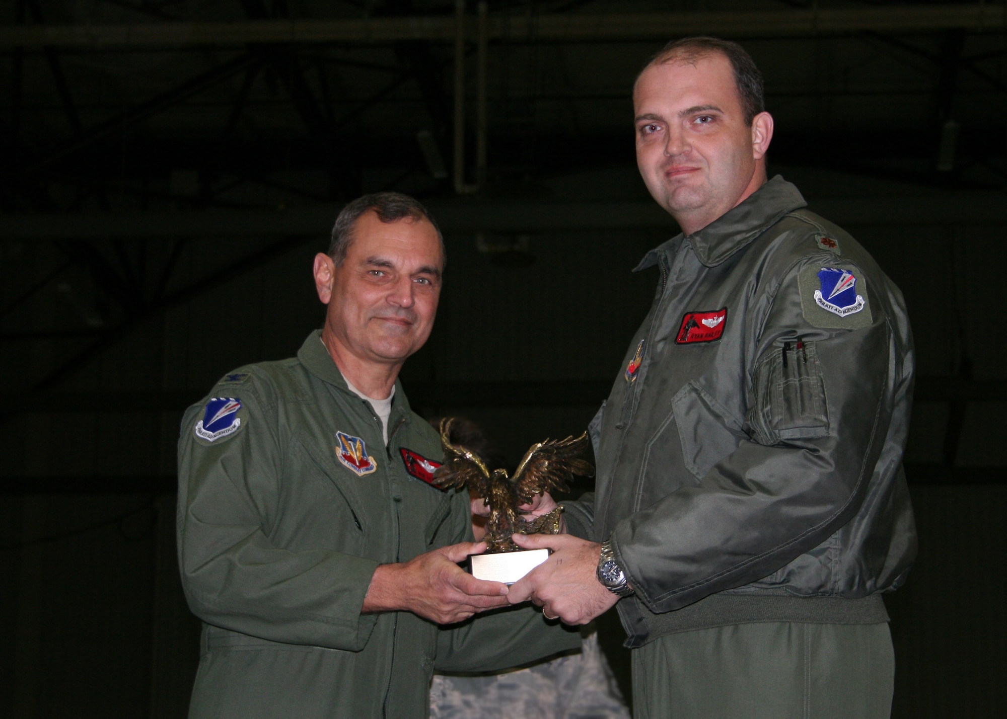 Maj Ryan "Poacher" Bailey, 131BW, receives an Eagle trophy from Col Robert Leeker, 131st Bomb Wing commander, at the 131st Outstanding Airman of the Year awards on Dec 5 at Whiteman Air Force Base.  Bailey was chosen as the 131st Outstanding Pilot of the Year-2009  (Air Force Photo by Tech Sgt Chris Boehlein   RELEASED) 