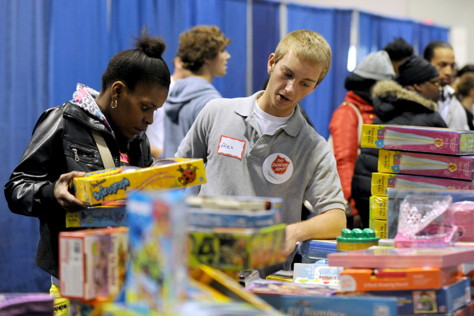 Syracuse area resident volunteer Alex assists a local mother in finding gifts for her children at the Oncenter Complex in Syracuse, NY on 22 Dec. 2009. Alex was a volunteer personal shopper at the Annual Christmas Bureau Salvation Army Food and Gift drive supplying needy families with gifts for their children and food for their Holiday meal. (US Air Force photo by Tech. Sgt. Jeremy M. Call/Released)