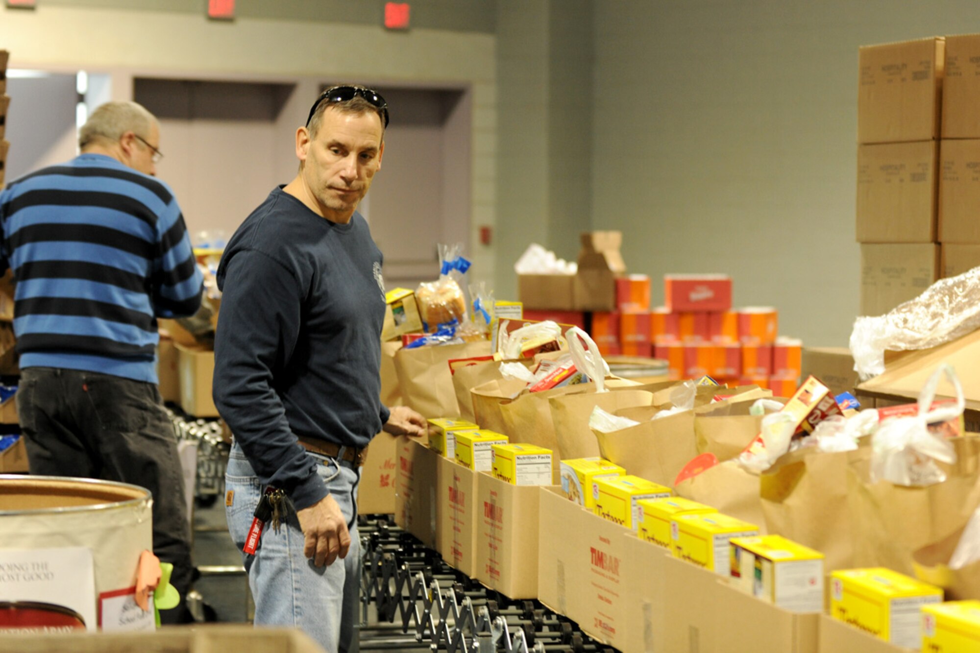 New York State Fire Fighter Mr. Timothy Bak fills boxes at the Oncenter Complex in Syracuse, NY on 22 Dec. 2009. Bak was volunteering at the Annual Christmas Bureau Salvation ArmyFood and Gift drive supplying needy families with gifts for their children and food for their Holiday meal. (US Air Force photo by Tech. Sgt. Jeremy M. Call/Released)