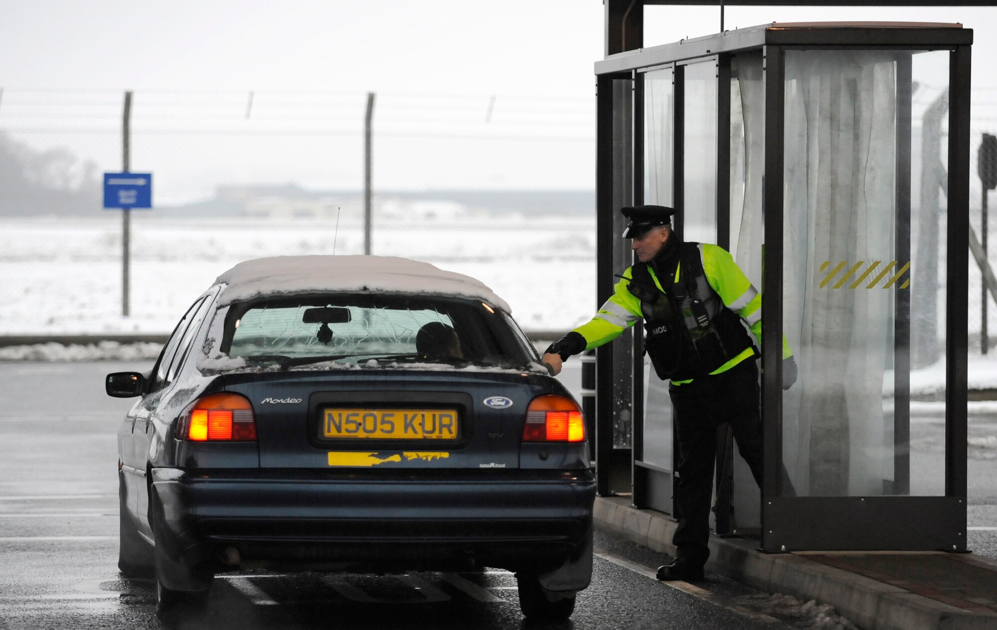 RAF MILDENHALL, England -- Paul Snelling, 100th Security Forces Squadron, checks identification cards in freezing weather Dec. 22.  Team Mildenhall members are reminded to drive safely in the hazardous road conditions.  (U.S. Air Force photo/Staff Sgt. Christopher L. Ingersoll)