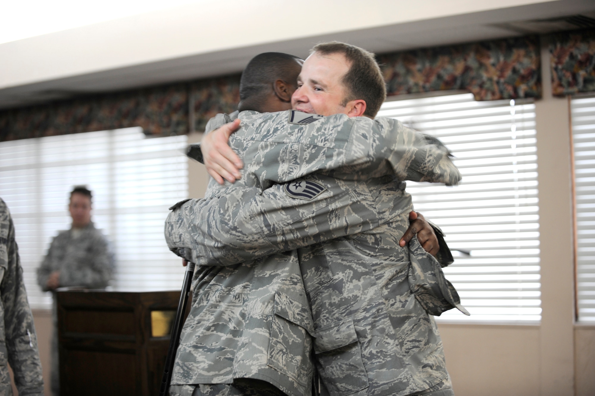 The lone survivor of an improvised explosive device attack on his Humvee while deployed to Afghanistan, Staff Sgt. Steve Light, right, gets a welcome-home bear hug during a ceremony in his honor Dec. 16 at MacDill Air Force Base. Sergeant Light’s experience, and his determination to continue serving his country, provided a lesson in dedication for all in attendance. (US Air Force Photo By: Senior Airman Angela Ruiz)