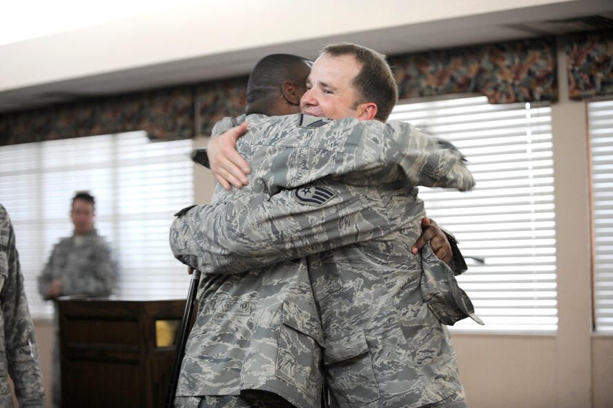 The lone survivor of an improvised explosive device attack on his Humvee while deployed to Afghanistan, Staff Sgt. Steve Light, right, gets a welcome-home bear hug during a ceremony in his honor Dec. 16 at MacDill Air Force Base. Sergeant Light’s experience, and his determination to continue serving his country, provided a lesson in dedication for all in attendance. (US Air Force Photo By: Senior Airman Angela Ruiz)