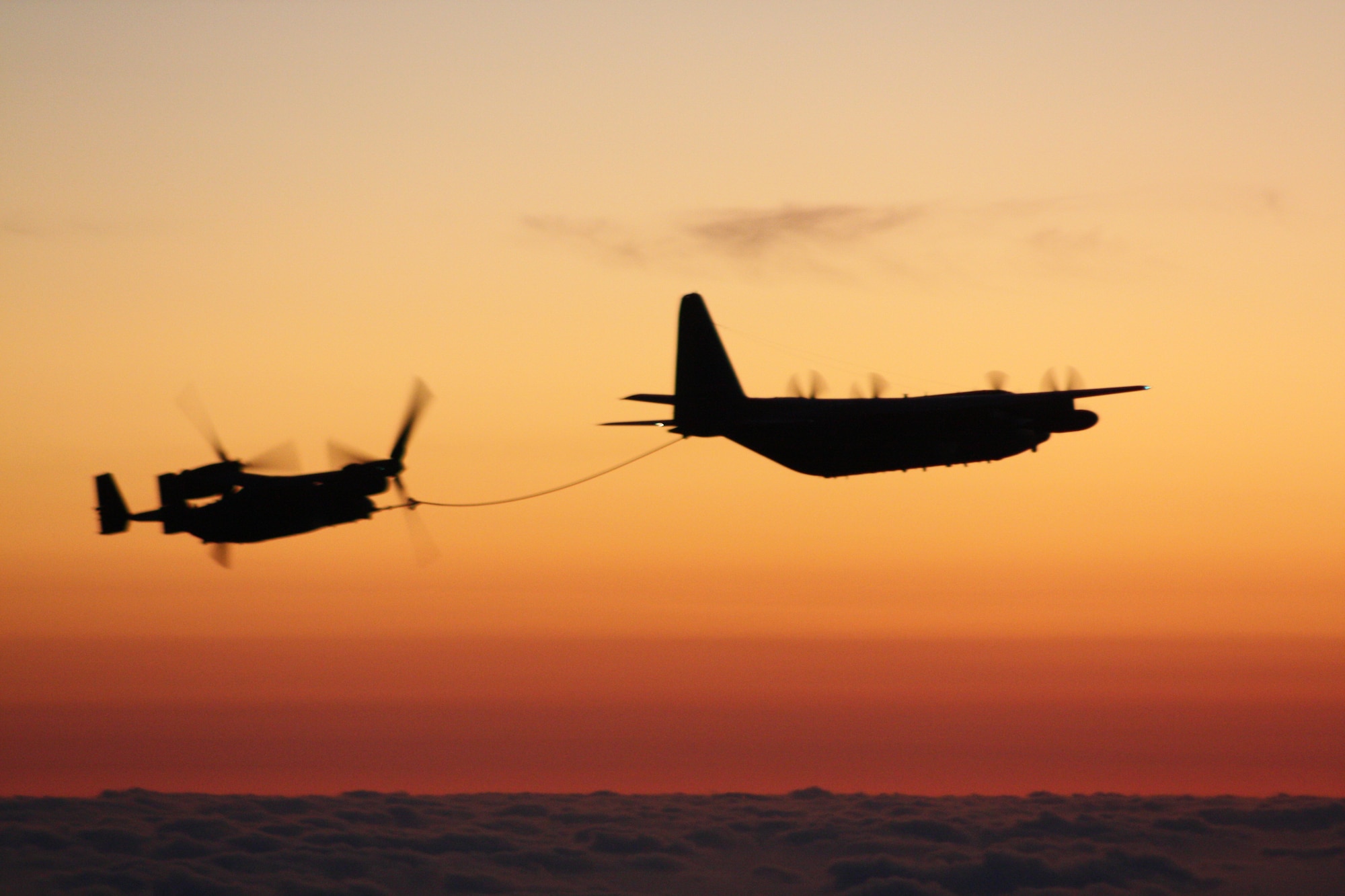 An RAF Mildenhall MC-130P Combat Shadow from the 352nd Special Operations Group refuels one of six CV-22 Osprey tiltrotor aircraft from Hurlburt Field, Fla., returning from their first combat tour. The 352nd SOG provided three Combat Shadows which passed more than 100,000 pounds of fuel to the CV-22s over a two-day period.  (U.S. Air Force photo/Capt. John Sisler) 