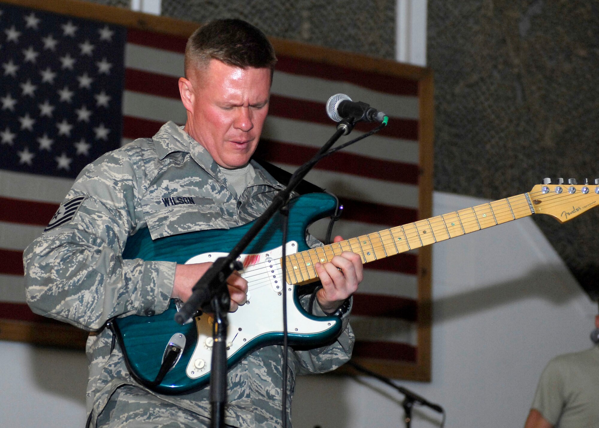 BAGRAM AIRFIELD, Afghanistan -- Tech. Sgt. Steve Wilson, a guitarist from the Sirocco, entertains the audience members with a song Dec. 23, 2009.  The AFCENT Band travels to different deployed locations to boost the morale of Servicemembers.  Sergeant Wilson is deployed from Lackland Air Force Base, Texas and hails from Austin, Texas.  (U.S. Air Force photo/Senior Airman Felicia Juenke)