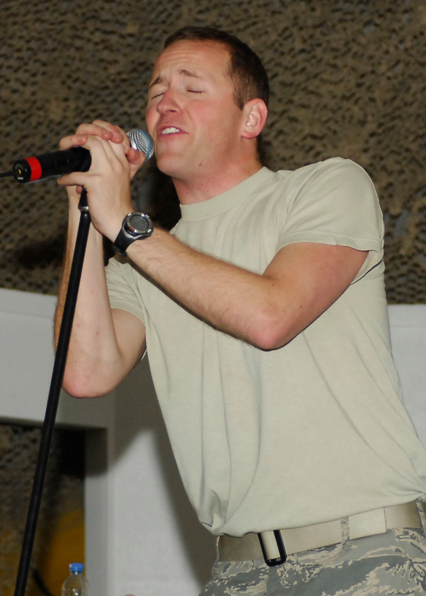 BAGRAM AIRFIELD, Afghanistan -- Airman 1st Class Clayton Lee, a vocalist from the Sirocco, entertains the audience members with a song Dec. 23, 2009.  The AFCENT Band travels to different deployed locations to boost the morale of Servicemembers.  Airman Lee is deployed from Lackland Air Force Base, Texas and hails from Fayetteville, N.C.  (U.S. Air Force photo/Senior Airman Felicia Juenke)