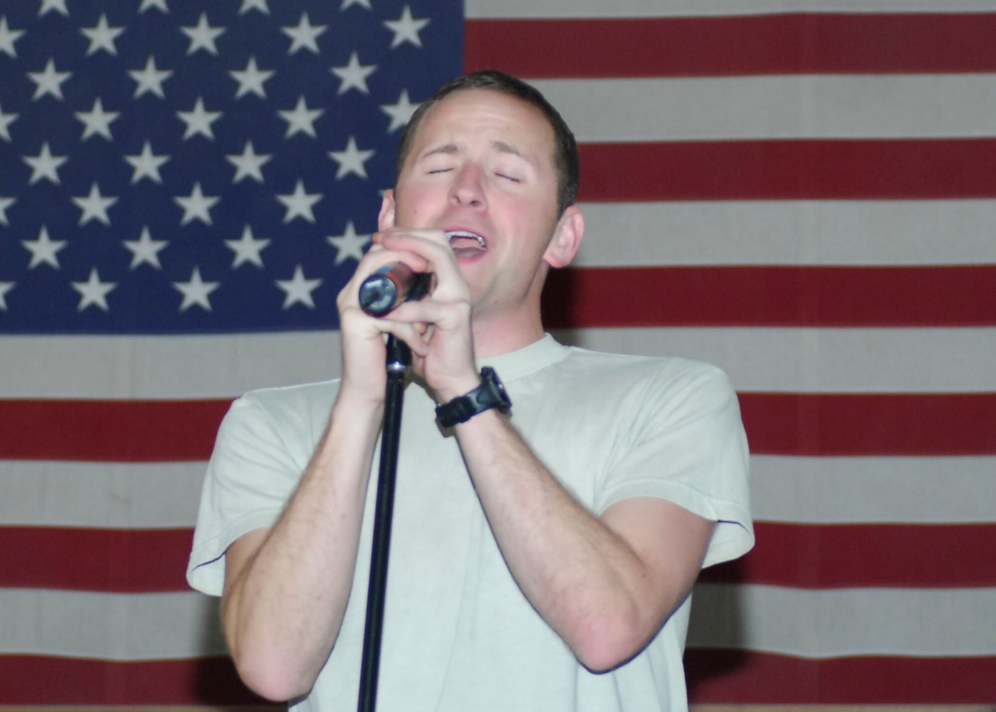 BAGRAM AIRFIELD, Afghanistan -- Airman 1st Class Clayton Lee, a vocalist from the Sirocco, entertains the audience members with a song Dec. 23, 2009.  The AFCENT Band travels to different deployed locations to boost the morale of Servicemembers.  Airman Lee is deployed from Lackland Air Force Base, Texas and hails from Fayetteville, N.C.  (U.S. Air Force photo/Senior Airman Felicia Juenke)
