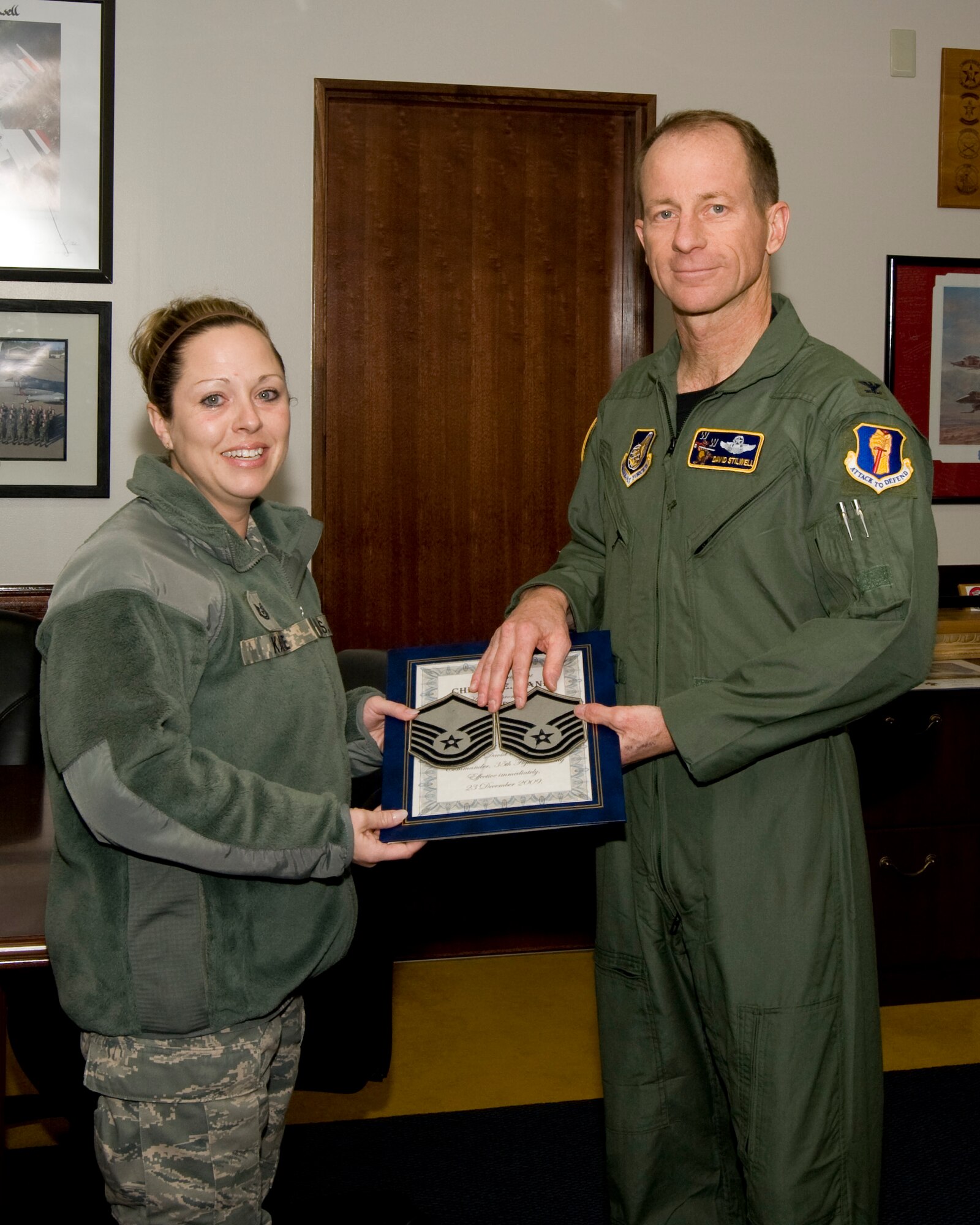 MISAWA AIR BASE, Japan -- Col. David Stilwell, 35th Fighter Wing commander, presents Tech. Sgt. Cheryl Kane, 35th FW Executive Knowledge Operations Flight NCO in charge, with a step promotion from technical sergeant to master sergeant Dec. 23 at the35th FW Headquarters building. Sergeant Kane was one of three Airmen to receive step promotions, her effective date of promotion will be Dec. 23. (U.S. Air Force photo/ Tech. Sgt. Russell McBride)
