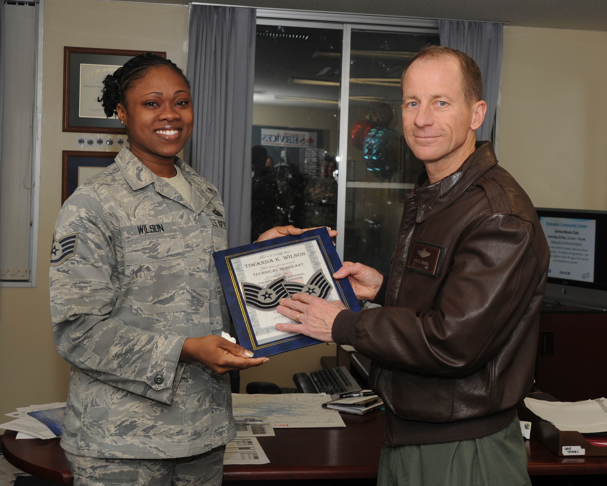 MISAWA AIR BASE, Japan -- Col. David Stilwell, 35th Fighter Wing commander, presents Staff Sgt. Tiwanda Wilson, 35th Force Support Squadron First Term Airman Center instructor, with a step promotion from staff sergeant to technical sergeant Dec. 23 at the 35th FSS commander’s office. Sergeant Wilson was one of three Airmen to receive step promotions, her effective date of promotion will be Dec. 23. (U.S. Air Force photo/ Tech. Sgt. Russell McBride)