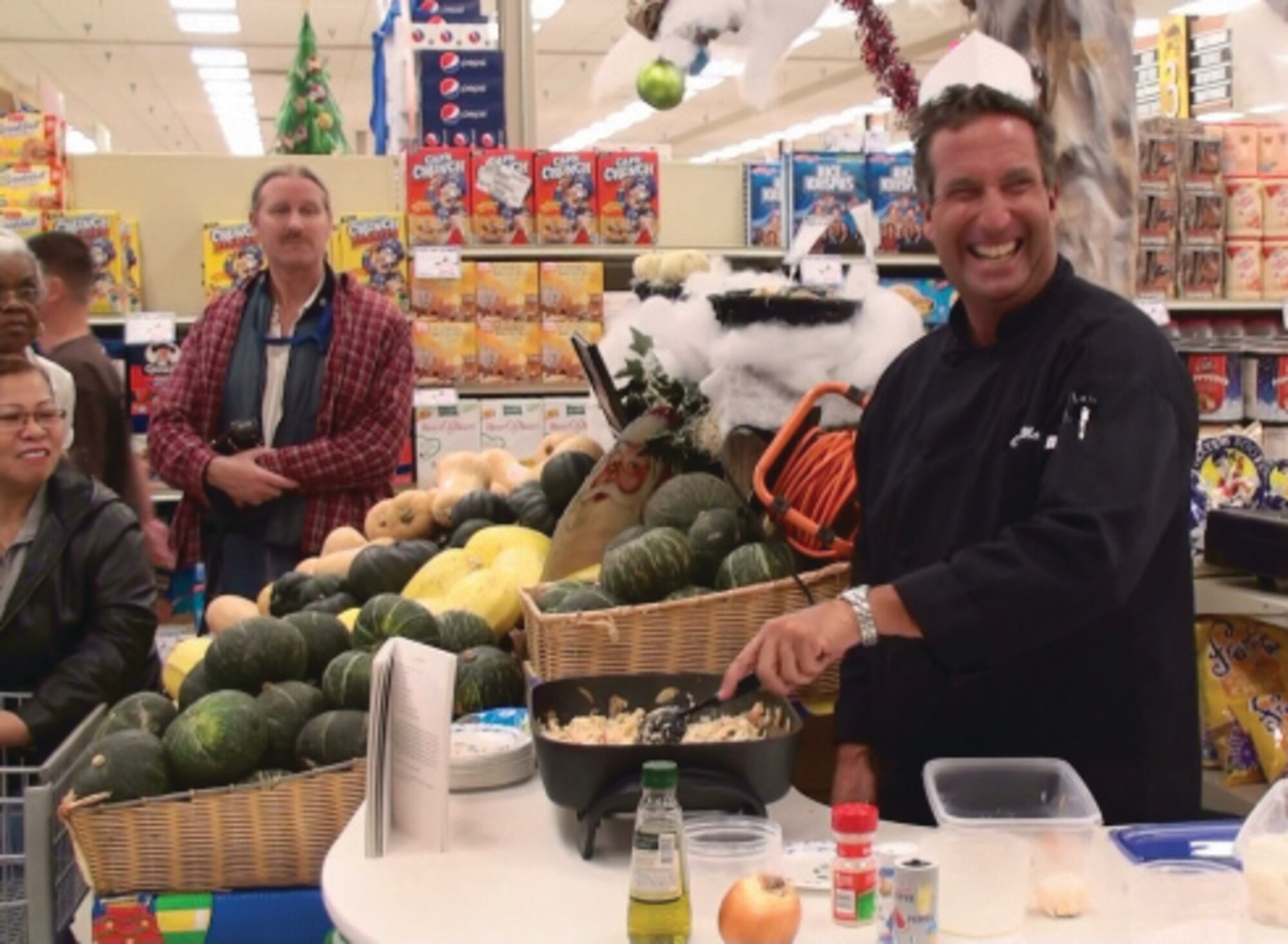 Master Chef Marc Cummings teaches March Commissary patrons how to prepare shrimp risotto in about 10 minutes with just a few ingredients last Sunday. He enjoys travelling to military bases and instructing military members on how to prepare gourmet meals with a handful of ingredients in a short amount of time. Chef Marc can be seen on the Food Network and is celebrity chef for Celebrity Cruise Lines. After the dish was prepared, he served the delicacy to the anxiously awaiting crowd. (U.S. Air Force photo by Master Sgt. Michael Blair)