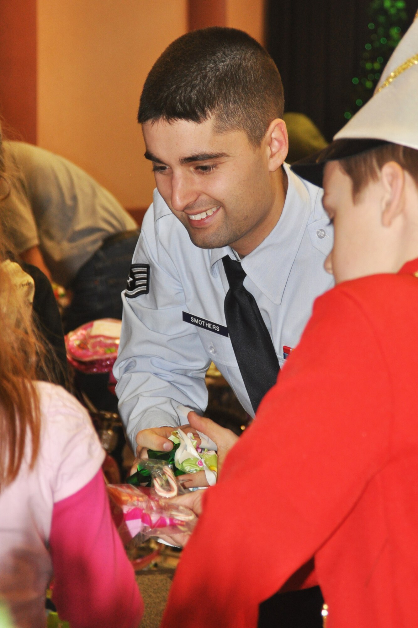 Staff Sgt. Neal Smothers, a missile analysis element technician for the 2nd Munitions Squadron on Barksdale Air Force Base, La., clears torn paper and trash from an unwrapping site at the Santas in Blues children’s party at the Bossier City Civic Center December 19, 2009. Each of the underprivileged foster children at the event received three gifts purchased with donations from numerous units and organizations, including the 917th Wing on Barksdale. Santas in Blues is designed to allow the Airmen on Barksdale the chance to bring Christmas to foster children in the Caddo, Bossier, Webster and De Soto parishes. (U.S. Air Force Photo/ Senior Airman Crystal Marie Jordan)