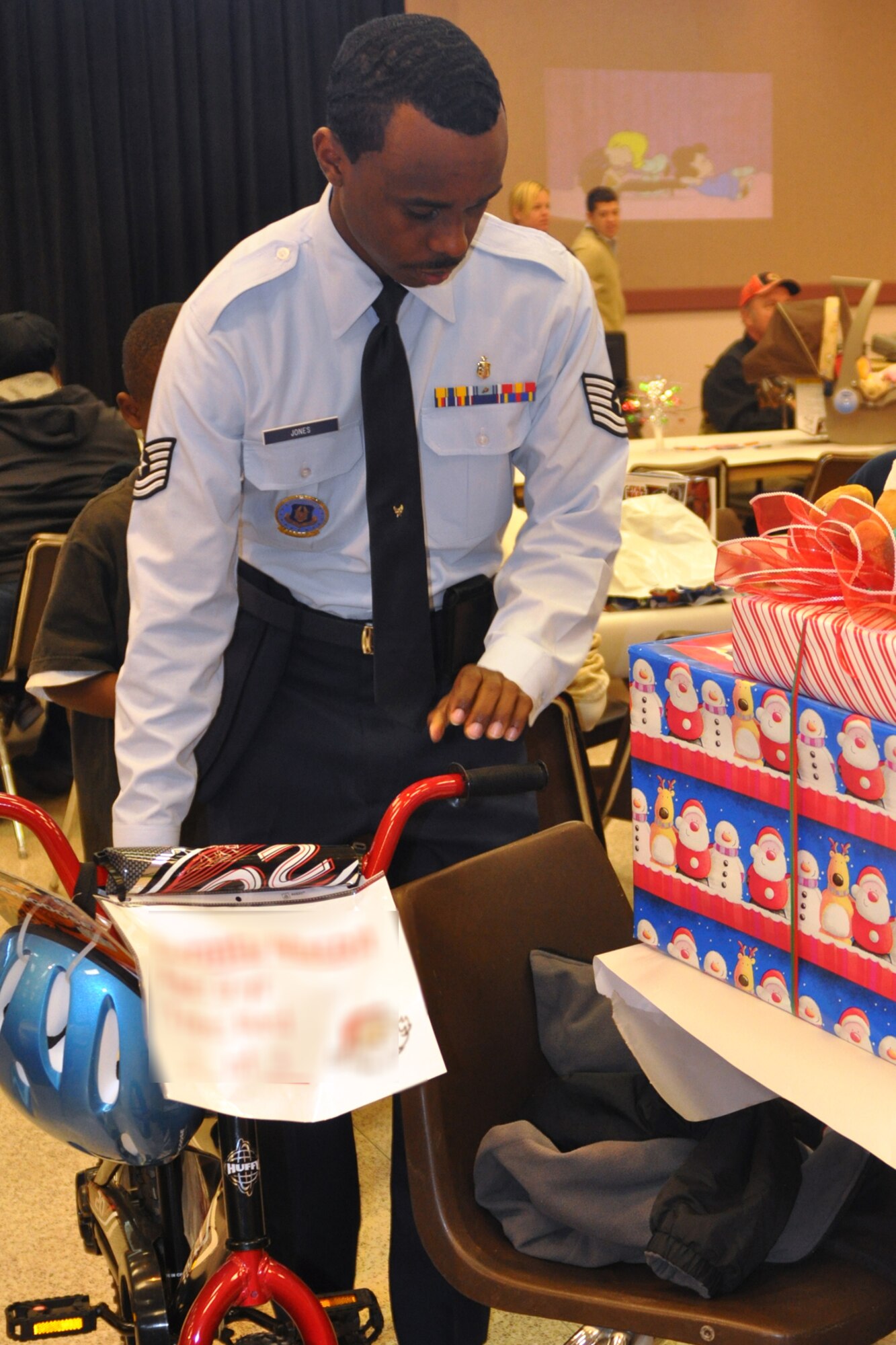Tech. Sgt. Anthony Jones, an Air Force Reserve recruiter for the 917th Wing on Barksdale Air Force Base, La., places a bicycle alongside two other gifts received by a foster child at the Santas in Blues children’s party at the Bossier City Civic Center December 19, 2009. Sergeant Jones is one of the many 917th Wing personnel who volunteered at the event. In total, the 917th Wing raised more than $6,000 for the program. Monetary donations were used to purchase Christmas gifts for the underprivileged foster children in the Caddo, Bossier, Webster and De Soto parishes as well as hosting the distribution parties for them. (U.S. Air Force Photo/ Senior Airman Crystal Marie Jordan)