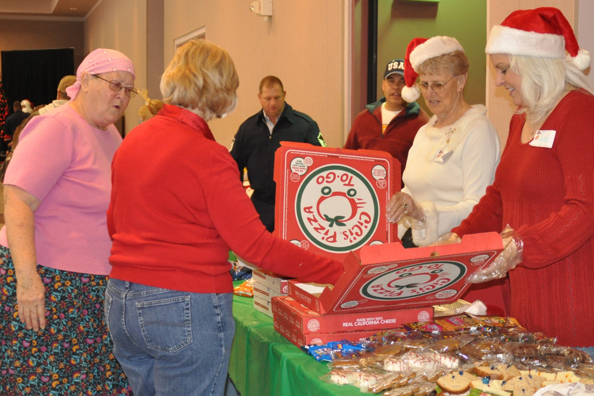 Volunteers from the Krewe of Centaur, a Mardi gras crew here in Shreveport, La., volunteer their time to serve food and beverages to the families in the foster care system during the Santas in Blues children’s party at the Bossier City Civic Center December 19, 2009. The “Krewe” spent their day handing food out to more than 350 foster children and their families that attended the party. Airmen from numerous units and organizations, including the 917th Wing at Barksdale Air Force Base, La., distributed donated gifts to the foster children in attendance.  (U.S. Air Force Photo/ Senior Airman Crystal Marie Jordan)