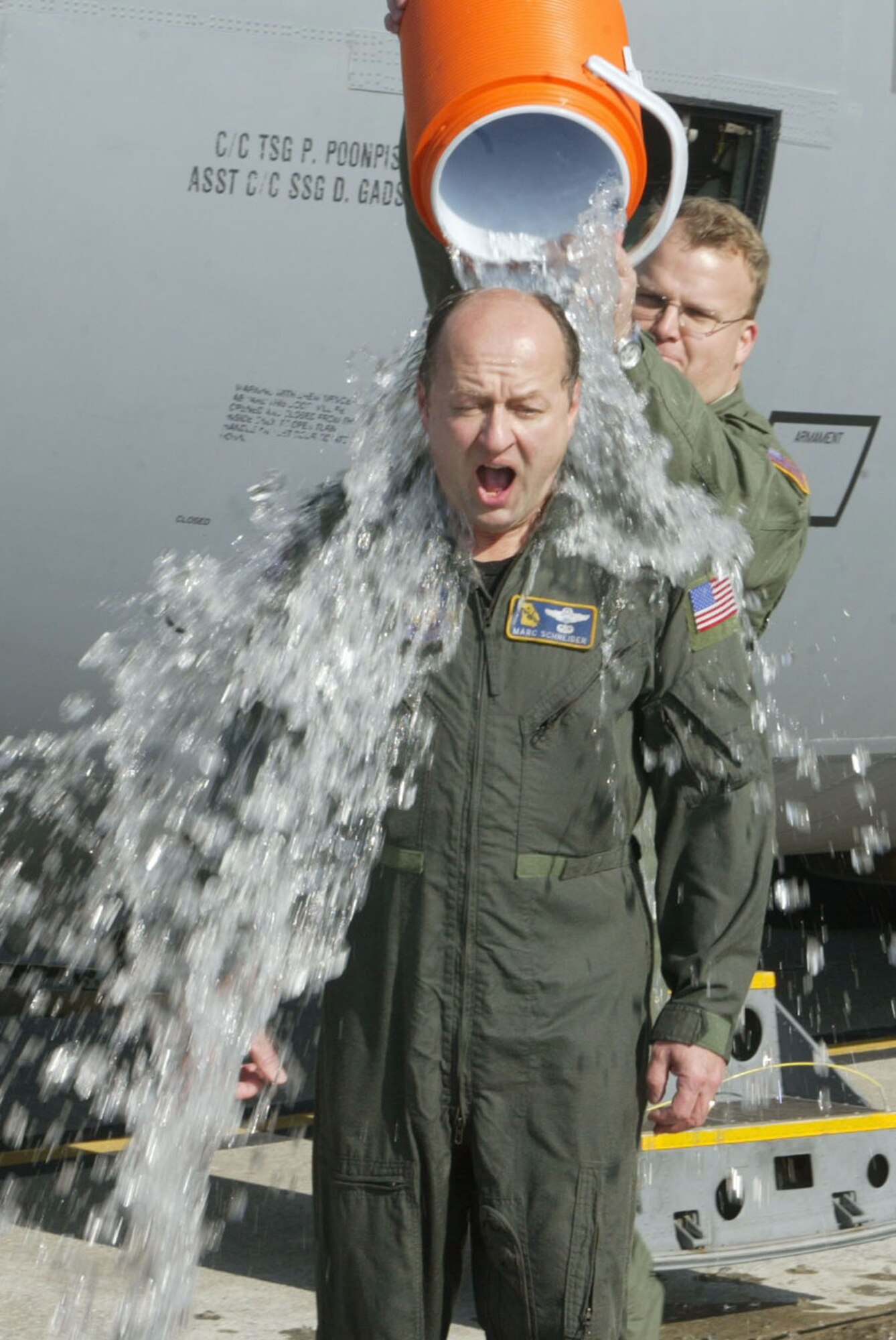 Lt. Col. Marc Schneider is greeted with the traditional soaking provided by crew member Master Sgt. Richard Graddy, as he steps out of a C-130 after completing his final flight Dec. 21. Colonel Schneider is assigned to the 700th Airlift Squadron and served 28 years in the U.S. Air Force, 20 of those years were with the 700th AS at Dobbins Air Reserve Base. (U.S. Air Force photo/Don Peek)
