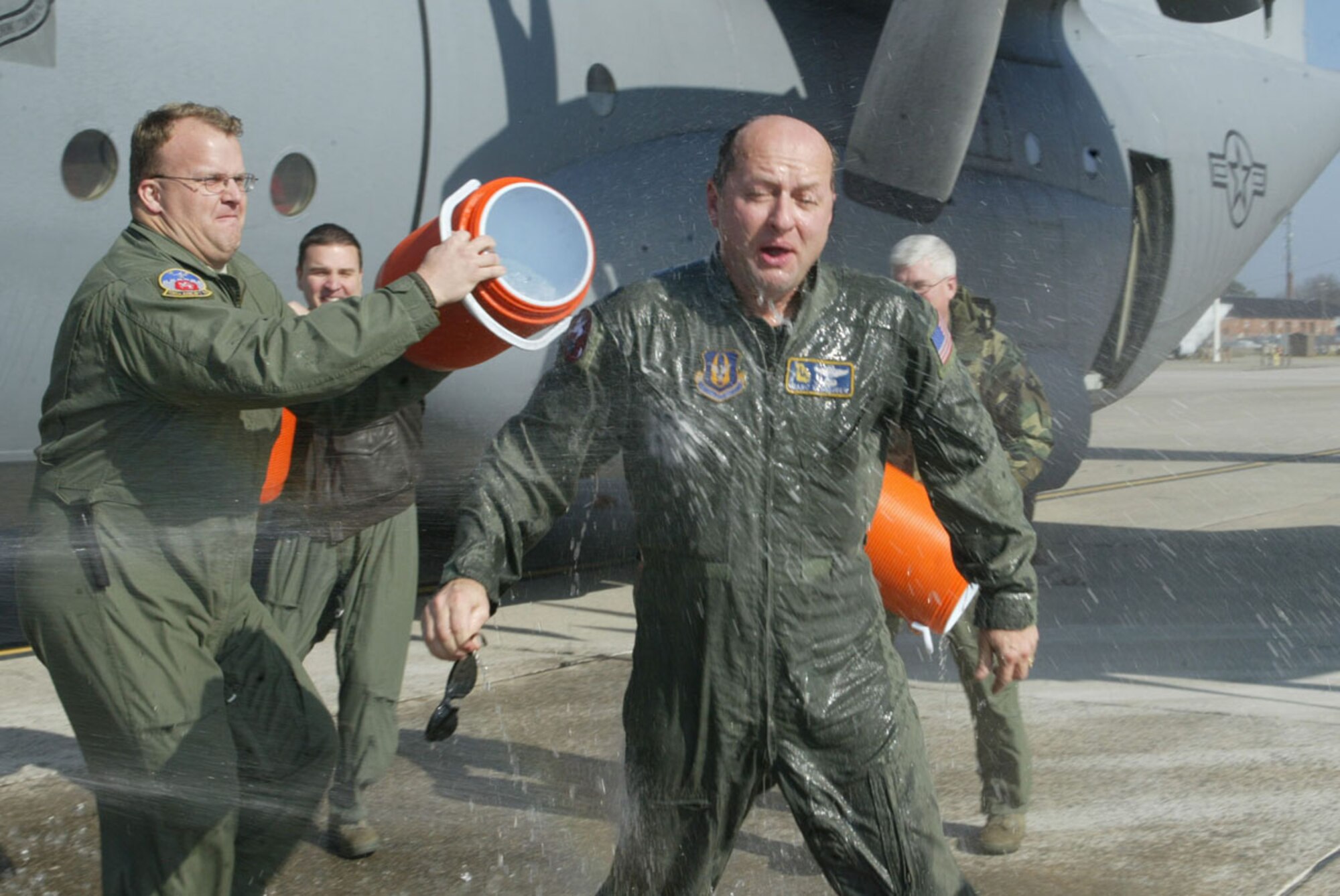 Lt. Col. Marc Schneider is greeted with the traditional soaking provided by his crew members as he steps out of a C-130 after completing his final flight Dec. 21. Colonel Schneider is assigned to the 700th Airlift Squadron and served 28 years in the U.S. Air Force, 20 of those years were with the 700th AS at Dobbins Air Reserve Base. (U.S. Air Force photo/Don Peek)
