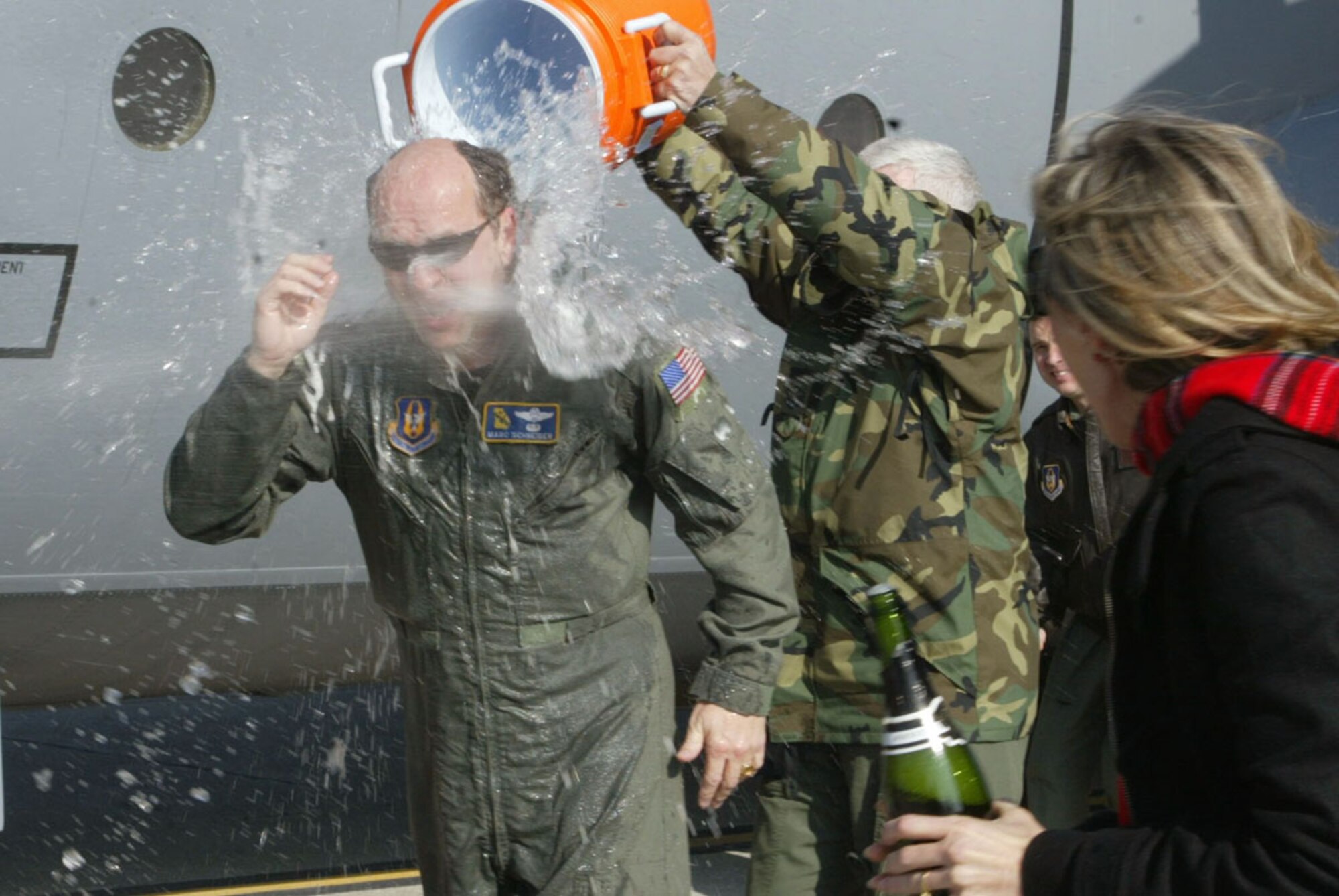 Lt. Col. Marc Schneider is greeted with the traditional soaking provided by crew member Master Sgt. Charles Lee as he steps out of a C-130 after completing his final flight Dec. 21. Colonel Schneider is assigned to the 700th Airlift Squadron and served 28 years in the U.S. Air Force, 20 of those years were with the 700th AS at Dobbins Air Reserve Base. (U.S. Air Force photo/Don Peek)
