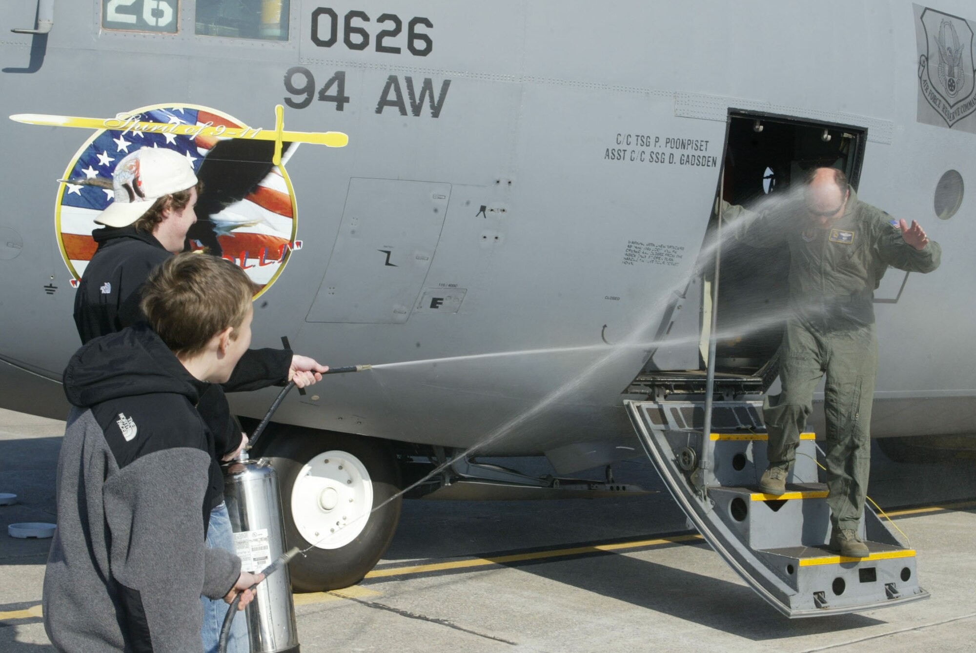 Lt. Col. Marc Schneider is greeted with the traditional soaking provided by his sons Andrew and Justin as he steps out of a C-130 after completing his final flight Dec. 21. Colonel Schneider is assigned to the 700th Airlift Squadron and served 28 years in the U.S. Air Force, 20 of those years were with the 700th AS at Dobbins Air Reserve Base. (U.S. Air Force photo/Don Peek)
