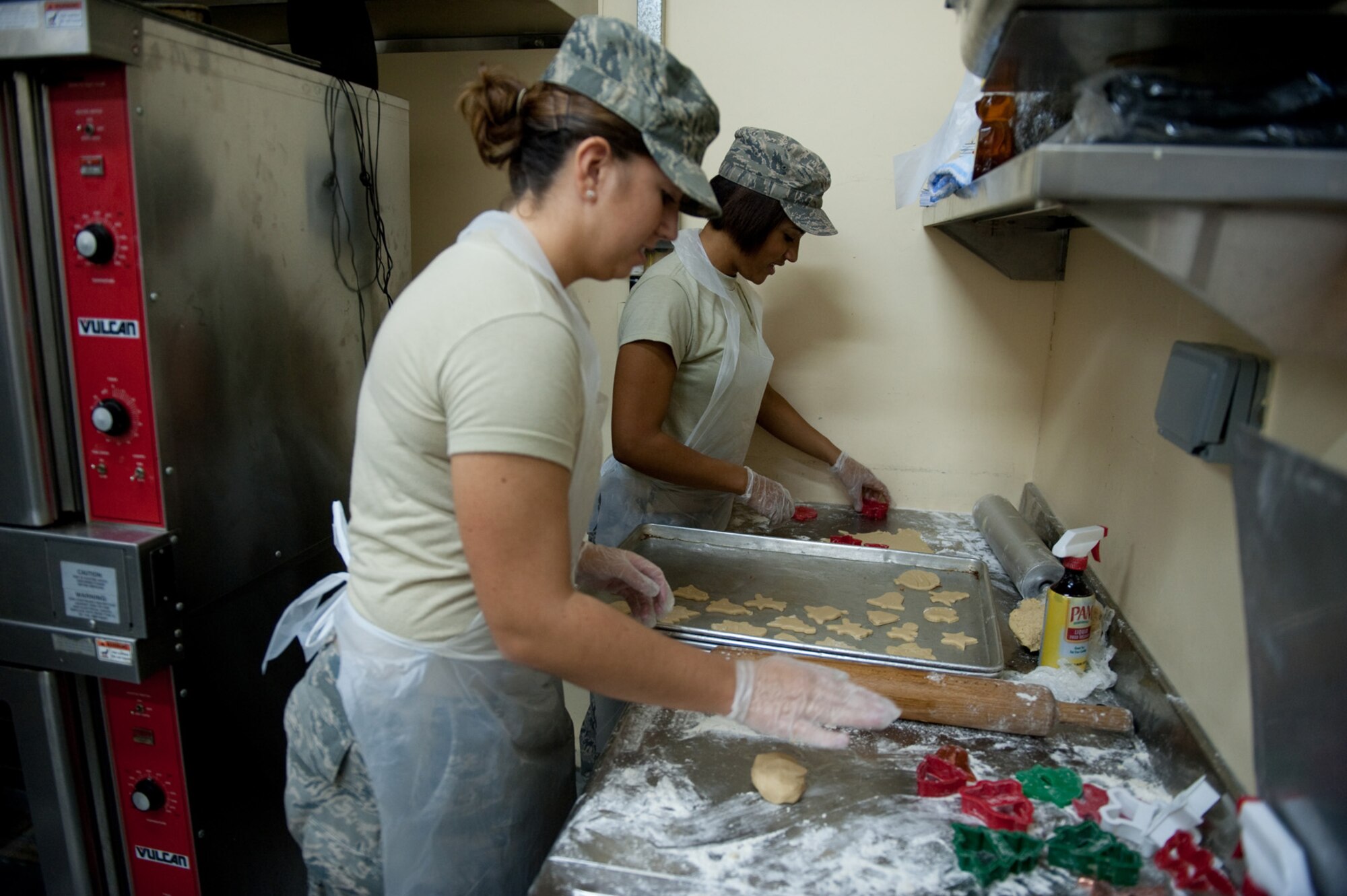 Left, Airman 1st Class Molly Holzem and Senior Airman Aja Blair, 379th Expeditionary Force Support Squadron, prepare holiday cookies for servicemembers, Dec. 23, 2009, in Southwest Asia. Airmen Holzem and Blair used a Holzem-family recipe to help those deployed during the holiday season feel more at home. (U.S. Air Force photo/Staff Sgt. Robert Barney)
