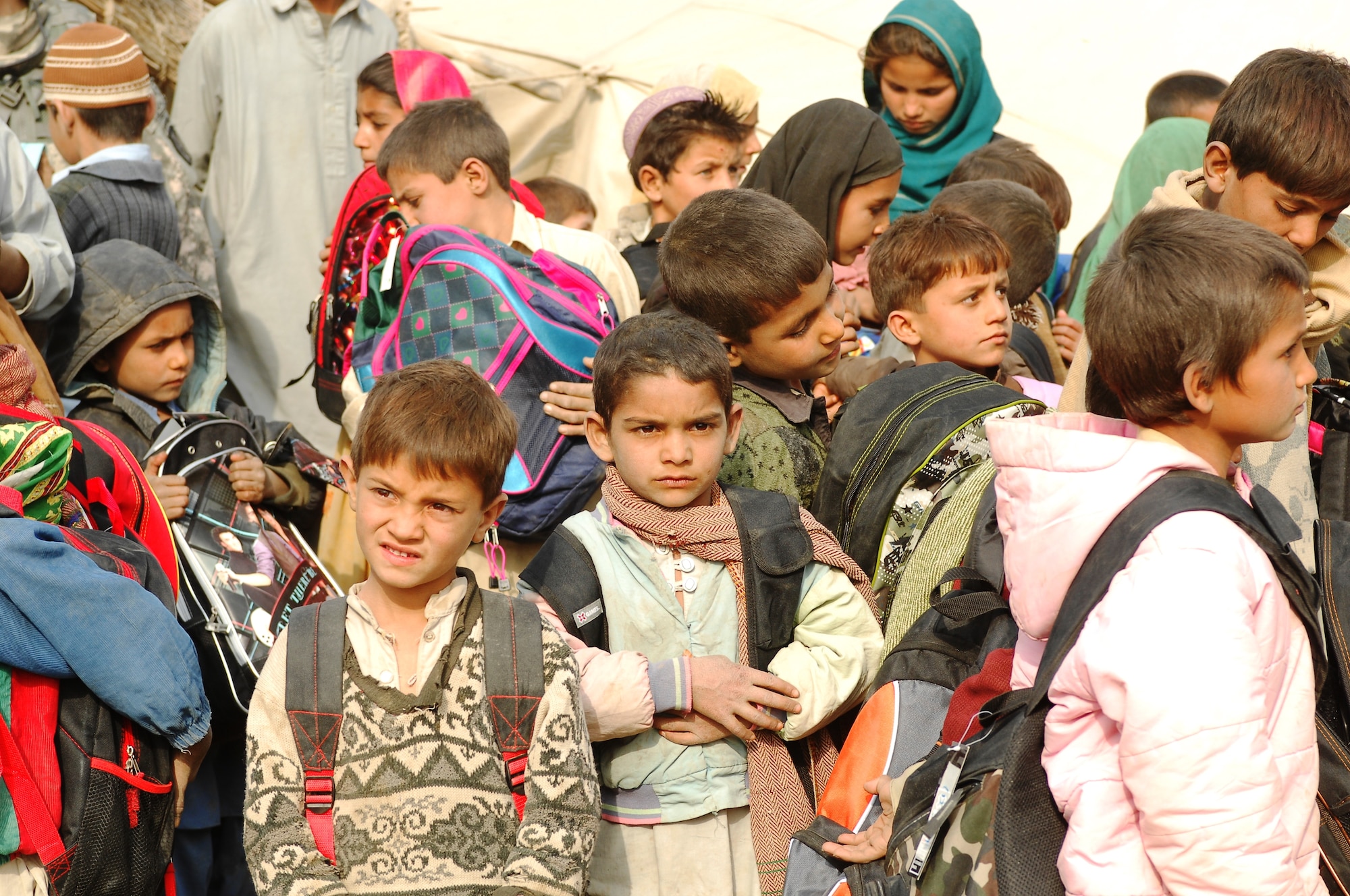 BAGRAM AIRFIELD, Afghanistan - Afghan children recently received new backpacks and school supplies from an American charity.  Four new schools in Donai, Bahrabat, Arazi and Zagrano are slated to be completed next summer.  The schools will provide a safe, sanitary learning environment for Afghan children when completed.  (U.S. Air Force photo/Senior Airman Felicia Juenke)