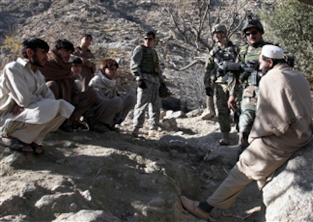 U.S. Army 1st Lt. John Cumbie, assigned to Delta Company, 2nd Battalion, 12th Infantry Regiment, 4th Brigade Combat Team, 4th Infantry Division, along with Afghan National Army Capt. Bashir (right), Commander of 3rd Company, 3rd Kandak speak with village members during a patrol in the Kolak village in Kunar province, Afghanistan, on Dec. 17, 2009.  