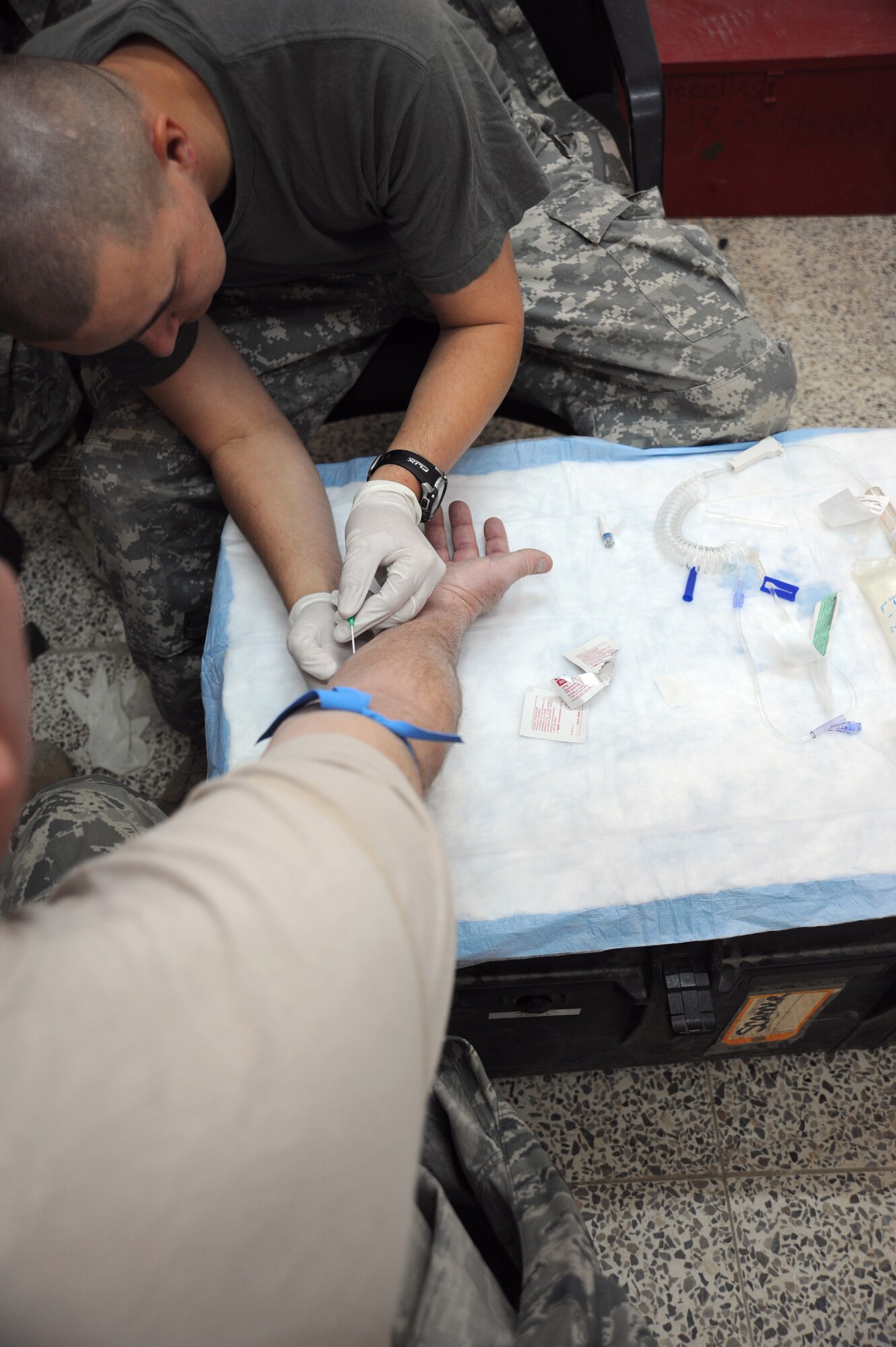 CAMP TAJI, Iraq -- Army Spc. Tommy Turner, a combat medic attached to the 732nd Expeditionary Security Forces Squadron Detachment 3, administers an intravenous injection to a unit member Dec. 12, 2009. Specialist Turner recently saved an Airman's life after his vehicle was hit by an explosively formed projectile while out on a mission. He is deployed from the 248th Area Support Medical Company, Georgia Army National Guard, and hails from Rome, Georgia. (U.S. Air Force photo/Master Sgt. Trish Bunting)