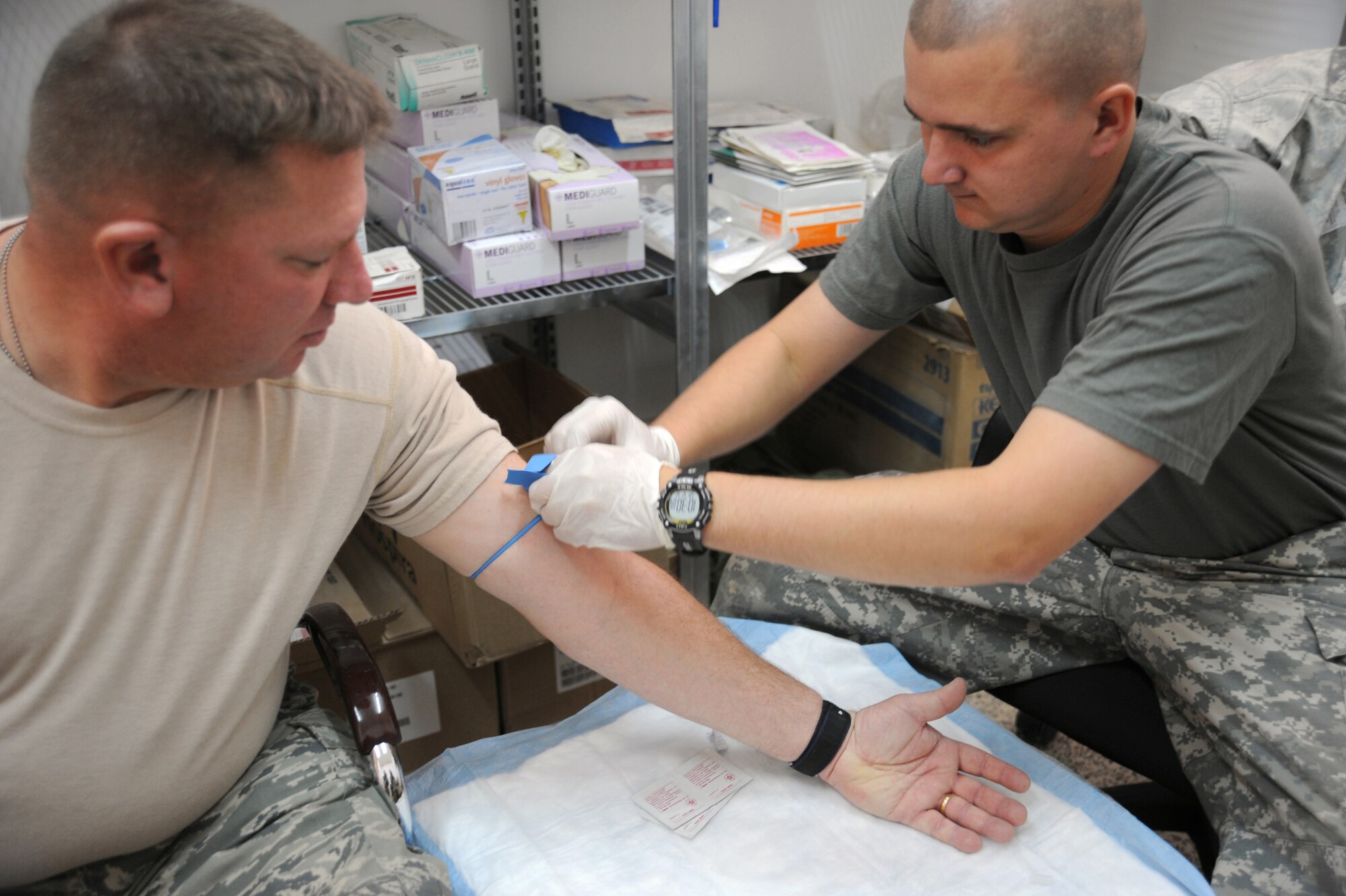 CAMP TAJI, Iraq -- Air Force Chief Master Sgt. Tim Ryan (left), security forces manager with the 732nd Expeditionary Security Forces Squadron Detachment 3, receives medical treatment from Army Spc. Tommy Turner, a combat medic attached to the 732nd ESFS Det. 3, Dec. 12, 2009. Specialist Turner recently saved an Airman's life after his vehicle was hit by an explosively formed projectile while out on a mission. Chief Ryan is deployed from Dyess Air Force Base, Texas, and hails from Oakfield, Wis. Specialist Turner is deployed from the 248th Area Support Medical Company, Georgia Army National Guard, and hails from Rome, Georgia. (U.S. Air Force photo/Master Sgt. Trish Bunting)