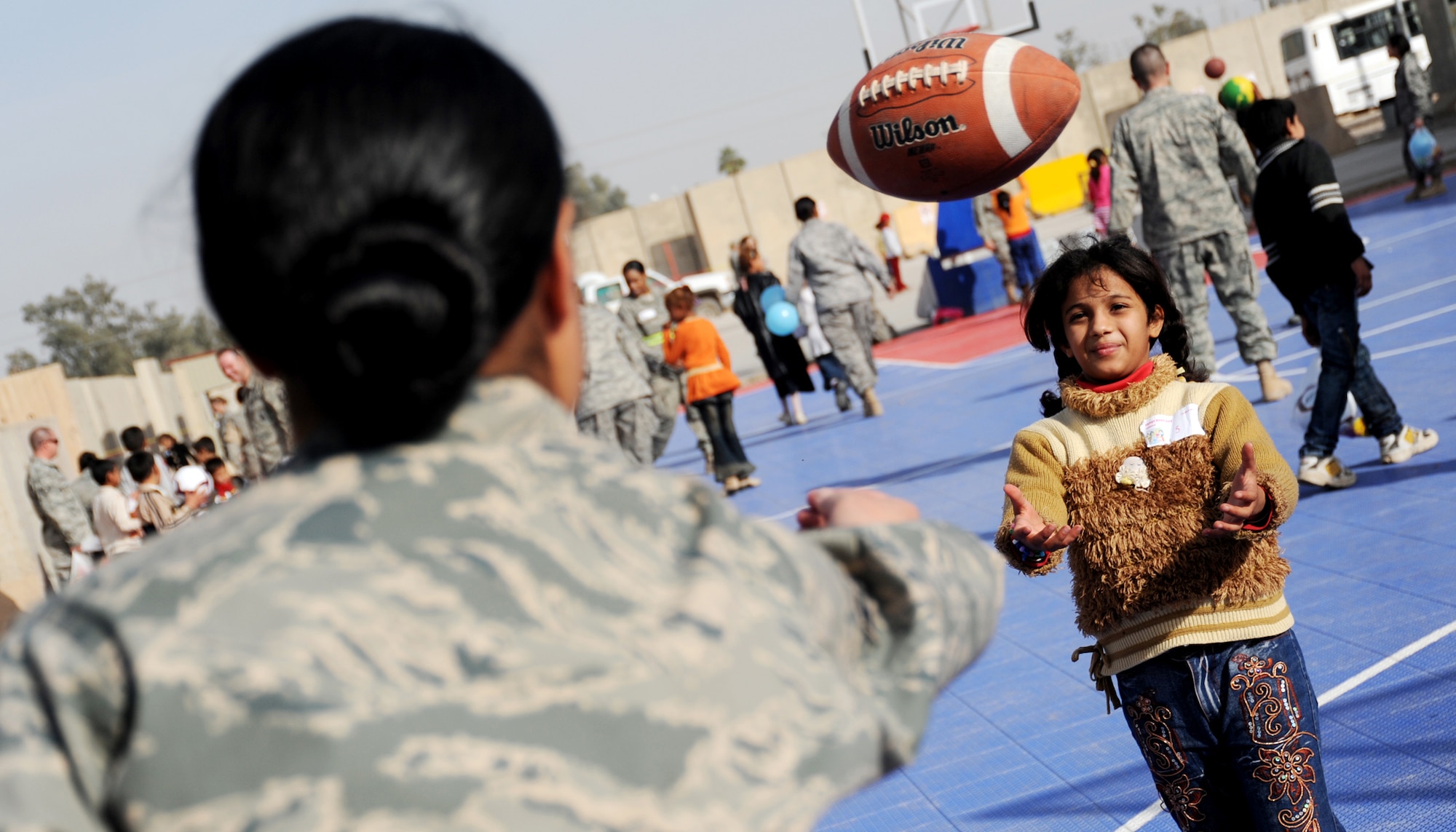 JOINT BASE BALAD, Iraq -- Airman 1st Class Valika Lagimaina of the 332nd Expeditionary Logistics Readiness Squadron plays with an Iraqi child during Iraqi Kids Day at the H-6 recreation area Dec. 19, 2009. The day provided servicemembers the opportunity to interact with and mentor local children. (U.S. Air Force photo/Senior Airman Christopher Hubenthal)
