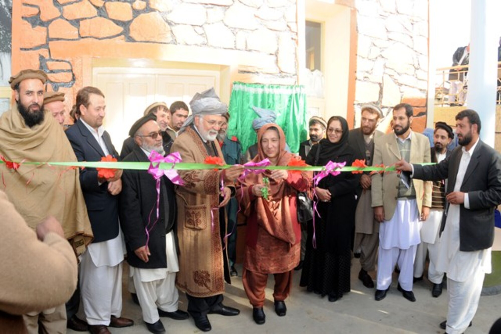 KUNAR PROVINCE, Afghanistan – Fazlullah Wahidi, Kunar provincial governor, Dr Asadullah Fazli, provincial Director of Public Health and Pashtoon Azfar, Afghan Midwife Committee chief take turns cutting the ribbon commemorating the opening of the Kunar Midwifery Program training center in Asadabad, Afghanistan, Dec. 22. The midwifery program will train 24 women from Kunar province in an 18-month long course on providing prenatal and post partum care to expectant mothers and their babies to decrease infant mortality rates. (U.S. Air Force photo/U.S. Air Force Tech. Sgt. Brian Boisvert)	