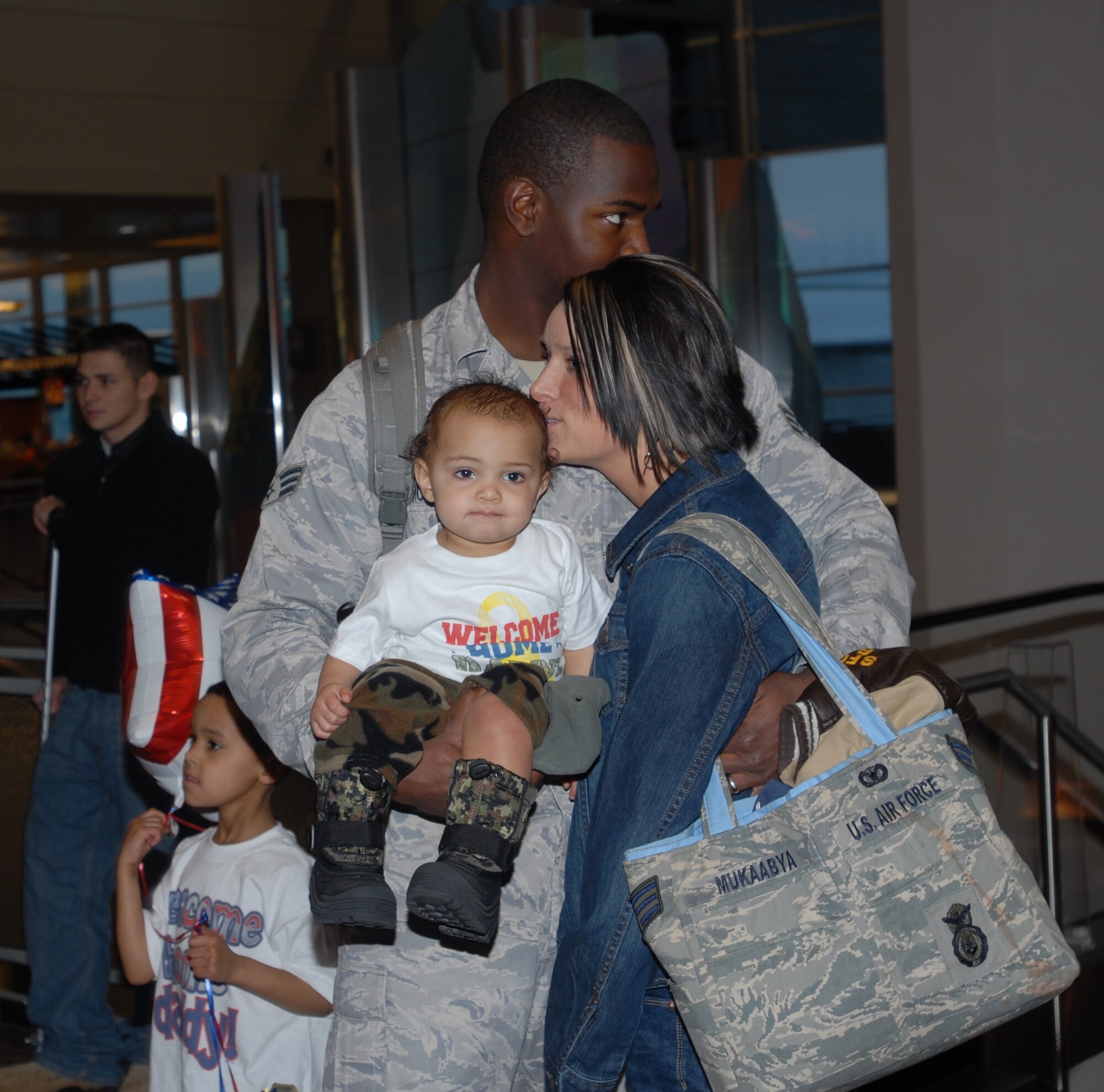 ELMENDORF AIR FORCE BASE, Alaska -- Senior Airman Michael Mukaabya gets reacquainted with his wife Tiffany and two sons Malachi and Tavian after returning home from deployment. Mukaabya is one of a dozen members from the 3rd Security Forces Squadron that returned from a six month deployment to Iraq on Christmas Day. (U.S. Air Force photo/Capt. Ashley Conner)