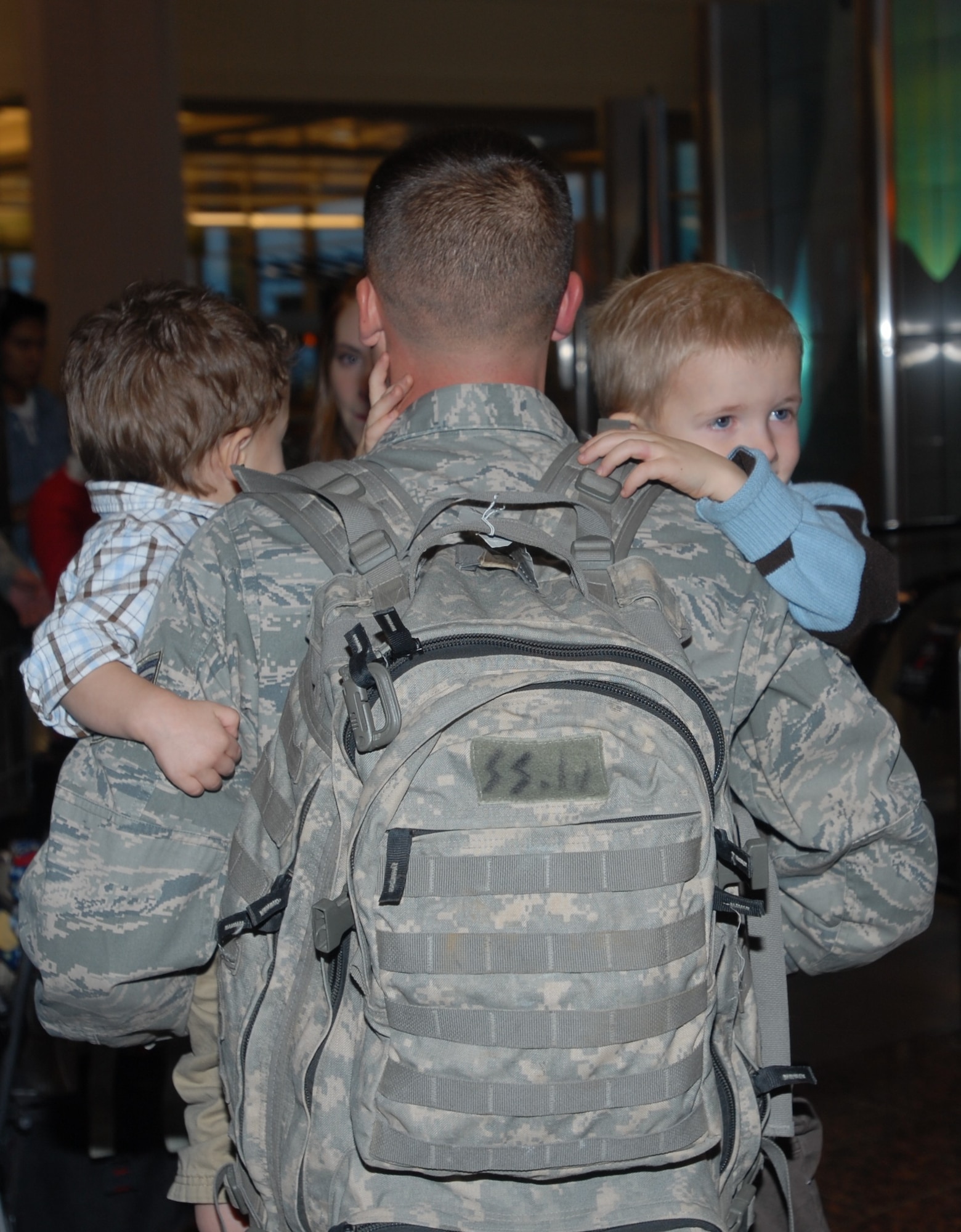 ELMENDORF AIR FORCE BASE, Alaska -- After deplaning Staff Sgt. Justin Silva carries his sons, Dillan and Connor. Not pictured are Silva’s wife, Kalyn, and two month old son, Caleb. Today was the first time Silva was able to see Caleb who was born while he was deployed to Iraq. Silva is one of a dozen members from the 3rd Security Forces Squadron that returned from a six month deployment to Iraq on Christmas Day. (U.S. Air Force photo/Capt. Ashley Conner)
