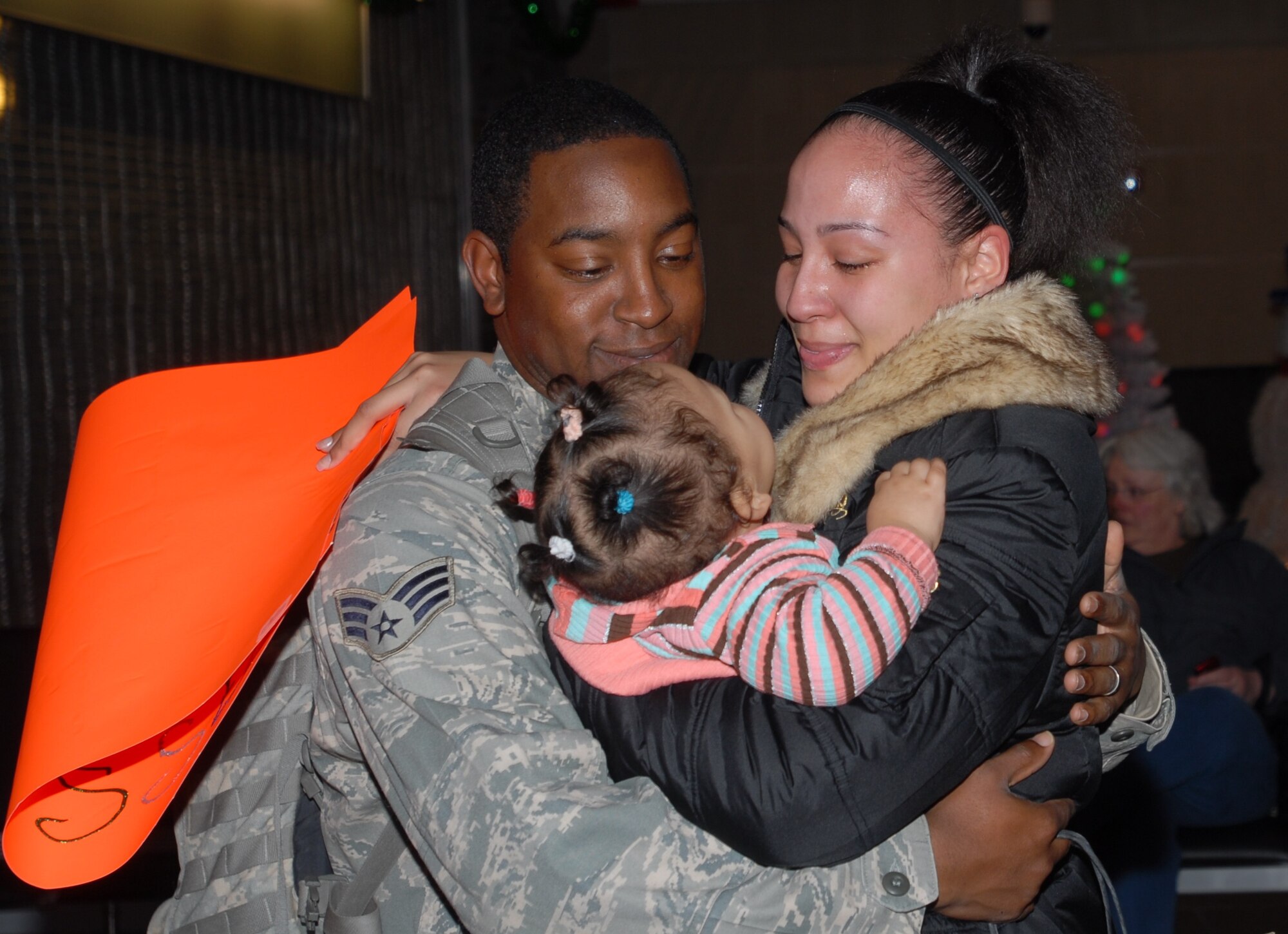 ELMENDORF AIR FORCE BASE, Alaska -- Senior Airman Shadrick Wynn is greeted by his wife Monique and 10-month-old daughter Amare after returning home on Christmas Day after a six-month deployment to Iraq. Wynn is one of a dozen members from the 3rd Security Forces Squadron greeted by friends and family at Ted Stevens Anchorage International Airport.  (U.S. Air Force photo/Capt. Ashley Conner)
