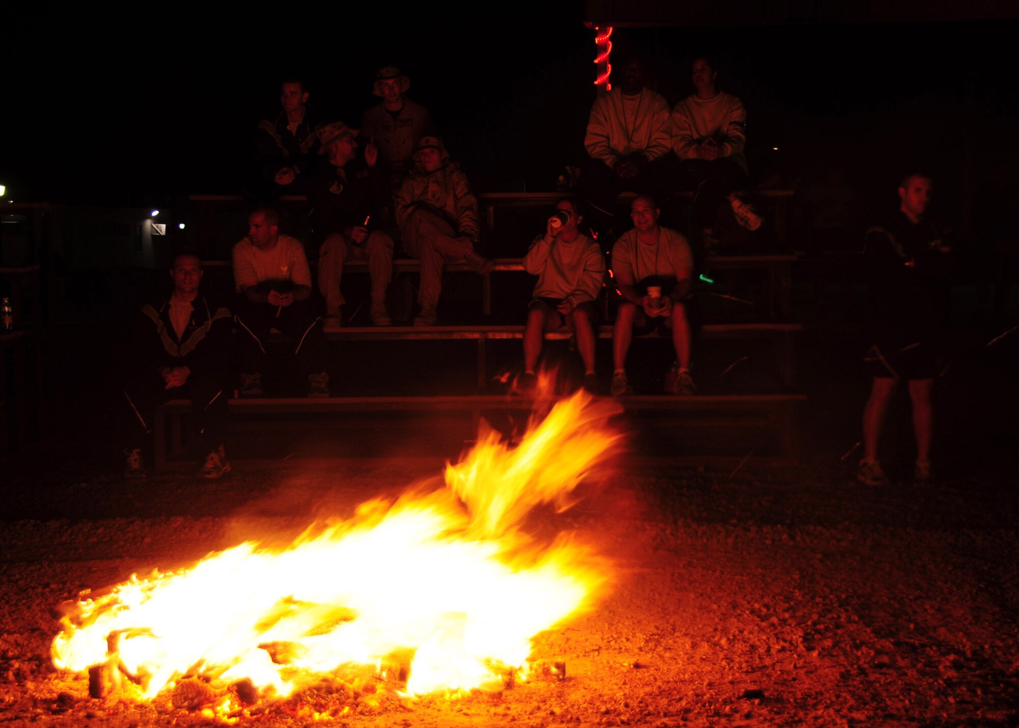 SOUTHWEST ASIA -- Members of the 386th Air Expeditionary Wing stay warm by a holiday bonfire Dec. 25, 2009 at an air base in Southwest Asia. During the evening festivities, the 386th AEW members roasted marshmallows, drank hot chocolate and watched an outdoor viewing of the movie "A Christmas Story".  (U.S. Air Force photo/Tech. Sgt. Tony Tolley)