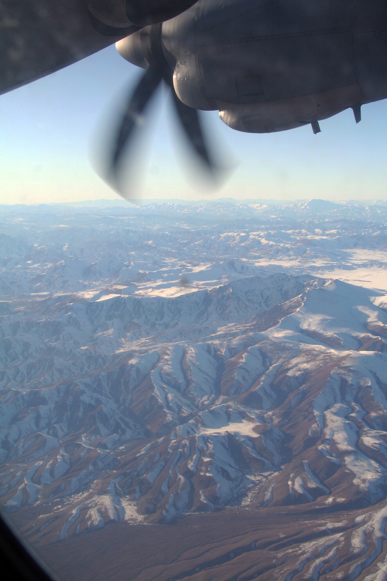 From the window of a C-130J Hercules, the mountainous terrain and a village in Afghanistan can be seen on Dec. 25, 2009. The C-130 was on an airlift mission for Operation Enduring Freedom. (U.S. Air Force Photo/Tech. Sgt. Scott T. Sturkol)
