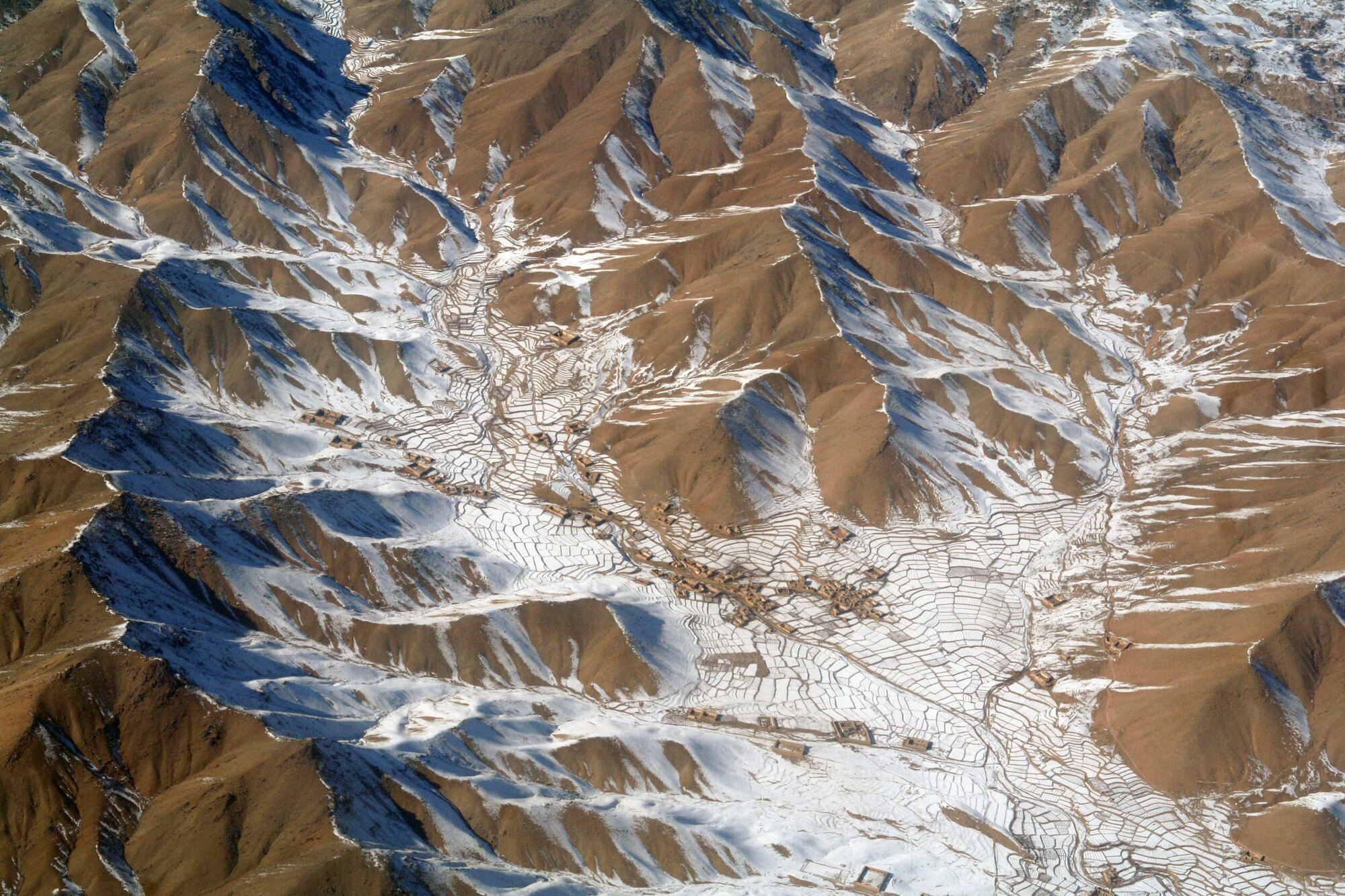 From the window of a C-130J Hercules, the mountainous terrain and a village in Afghanistan can be seen on Dec. 25, 2009. The C-130 was on an airlift mission for Operation Enduring Freedom. (U.S. Air Force Photo/Tech. Sgt. Scott T. Sturkol)