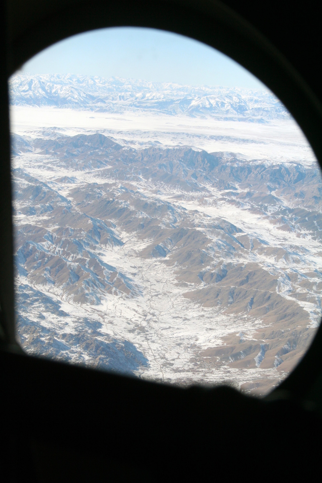 Through the window of a C-130J Hercules, the mountainous terrain of Afghanistan can be seen on Dec. 25, 2009. The C-130 was on an airlift mission for Operation Enduring Freedom. (U.S. Air Force Photo/Tech. Sgt. Scott T. Sturkol)