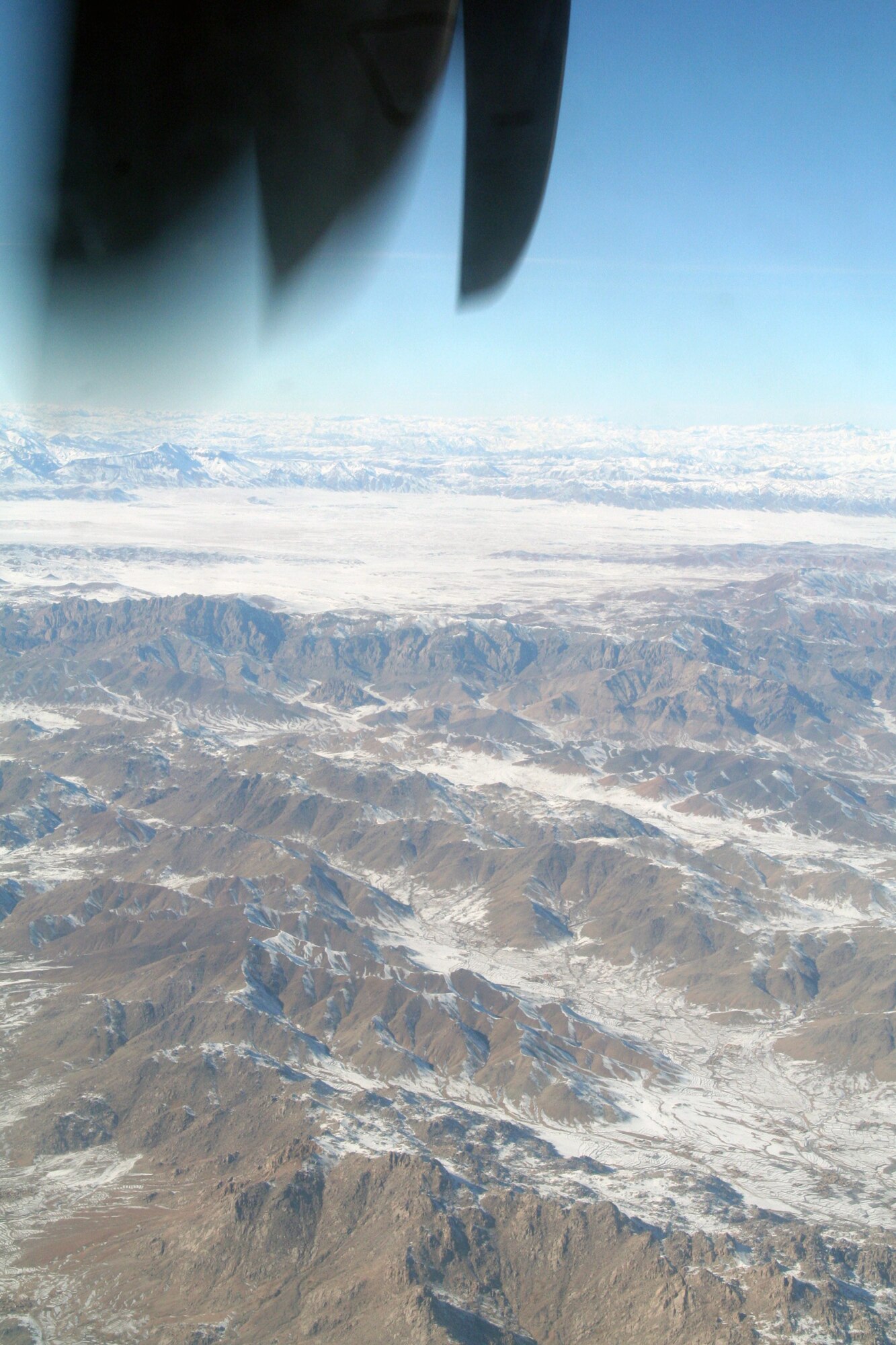 Through the window of a C-130J Hercules, the mountainous terrain of Afghanistan can be seen on Dec. 25, 2009. The C-130 was on an airlift mission for Operation Enduring Freedom. (U.S. Air Force Photo/Tech. Sgt. Scott T. Sturkol)