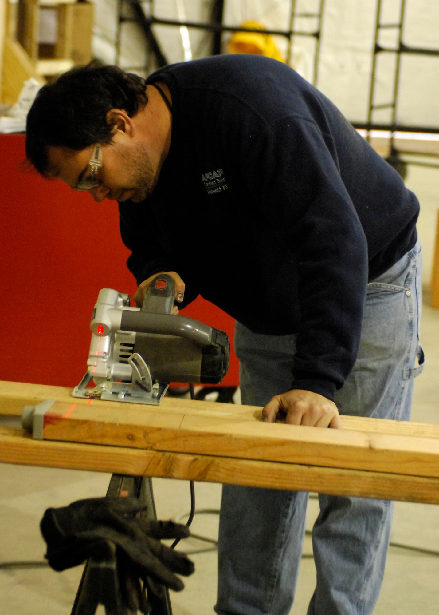 BAGRAM AIRFIELD, Afghanistan -- Scott Paulson, an Exira, Iowa native, cuts wood to build the frame for a door Dec. 24, 2009.  Mr. Paulson is one of the team members sent to build the 4th Expeditionary Reconnaissance Squadron hangar before the personnel and aircraft arrive.  The Air Force MC-12s bring another capability to Operation Enduring Freedom because the MC-12 is not just an aircraft, but a complete collection, processing, analysis and dissemination system of Airmen committed to securing Afghanistan and protecting Afghan and Coalition lives.  (U.S. Air Force photo/Senior Airman Felicia Juenke)