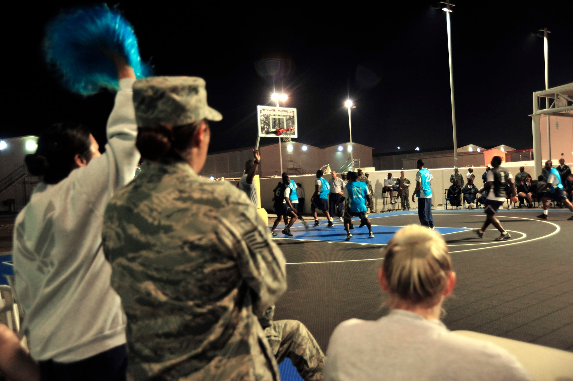 Members of the 380th Air Expeditionary Wing cheer on their favorite team during the 380th Expeditionary Force Support Squadron morale basketball tournament at an undisclosed location in Southwest Asia on Dec. 26, 2009. Force support sponsored the basketball tournament to increase morale within the base. (U.S. Air Force Photo/Senior Airman Jenifer H. Calhoun) 